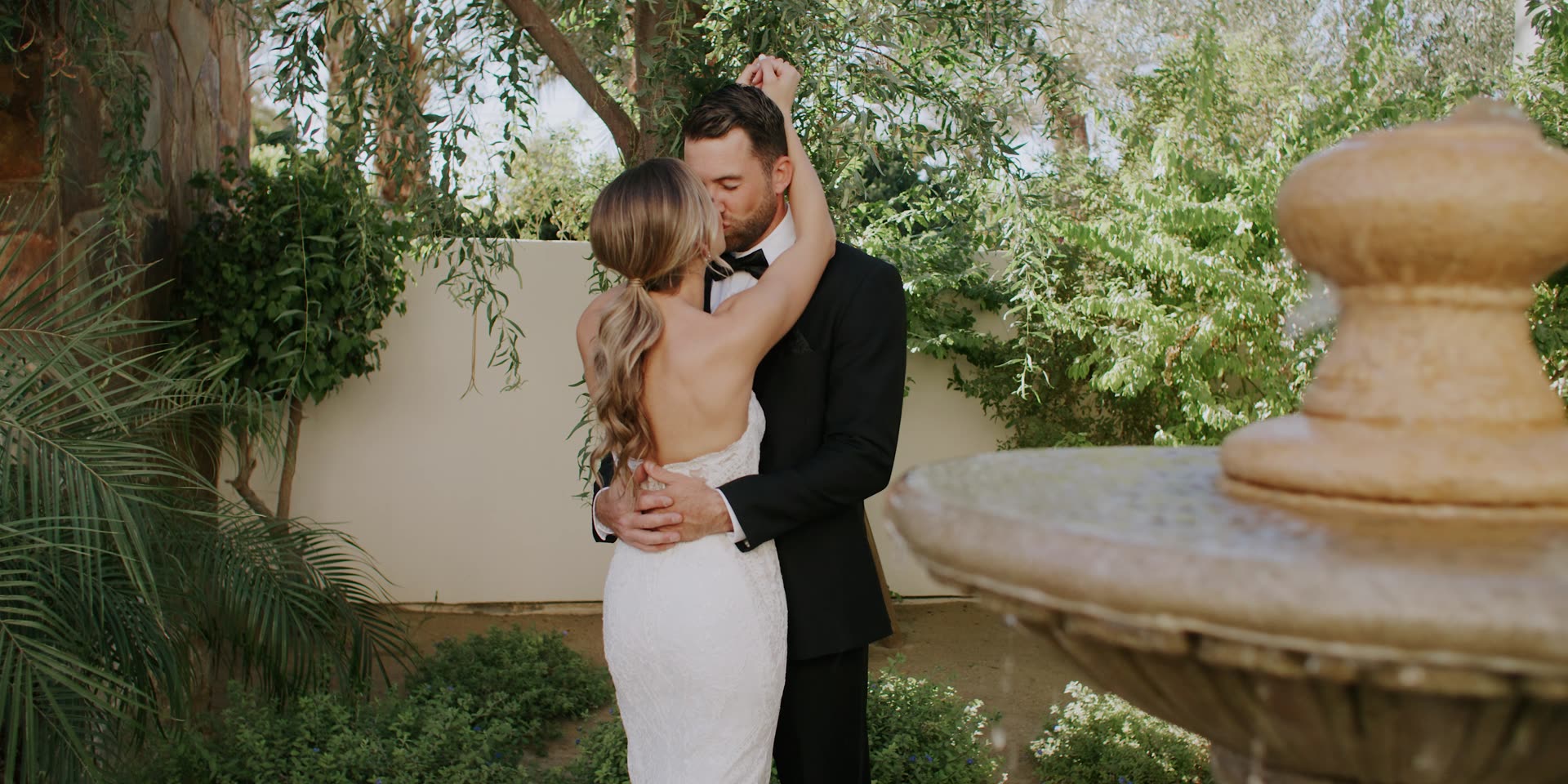 Andrew and Angelique together beside the stone fountain at Old Polo Estate