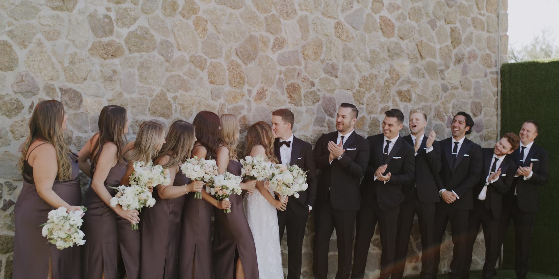 The wedding party against the stone wall at Cielo Farms