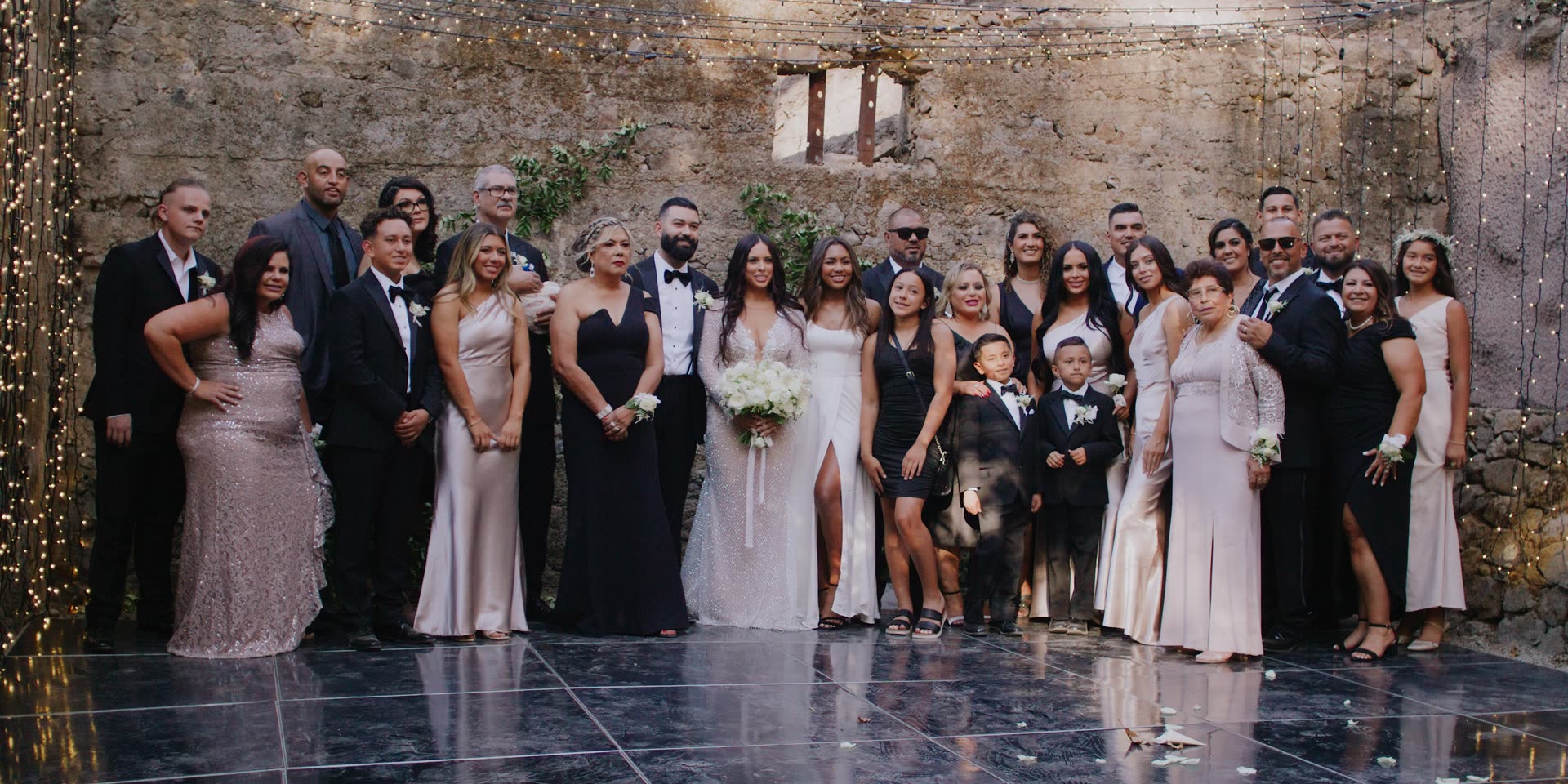 The wedding party gathered against the old stone wall at the Calistoga estate