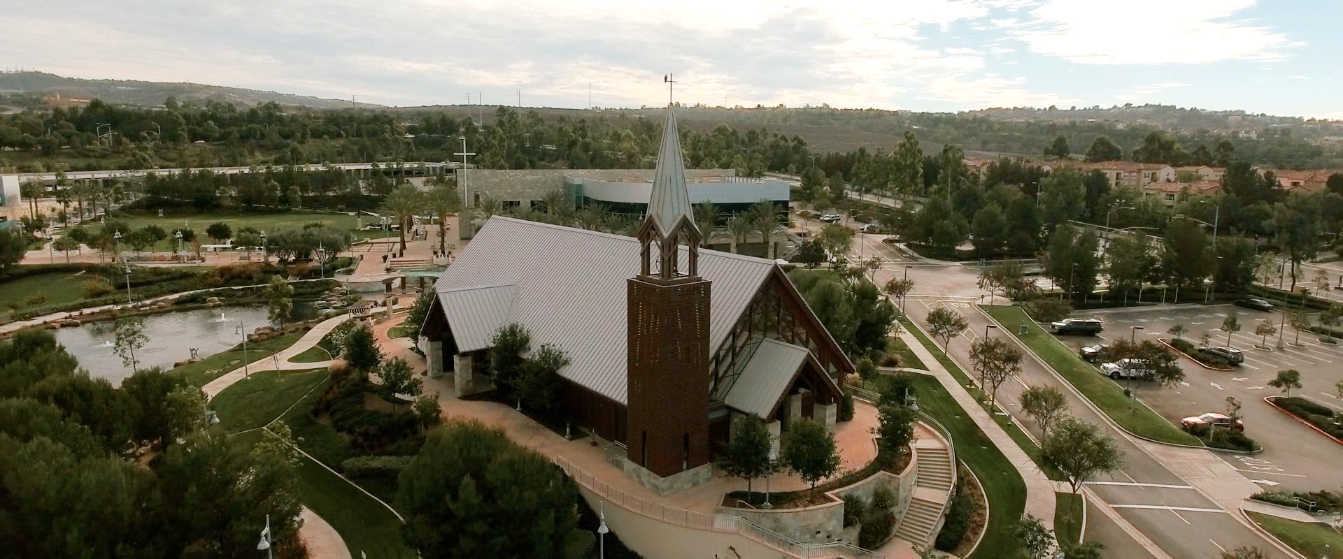 The brick bell tower and steeple at Mariners Church, Irvine, with the surrounding campus and hills behind