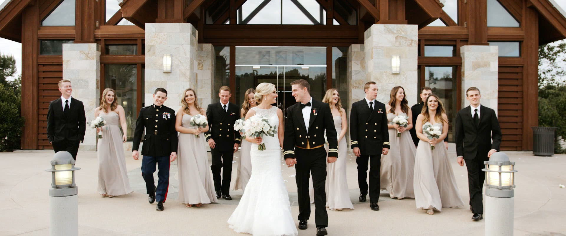 Andrew and Kendal walking out of Mariners Church with their wedding party, groomsmen in Navy and Marine dress uniforms