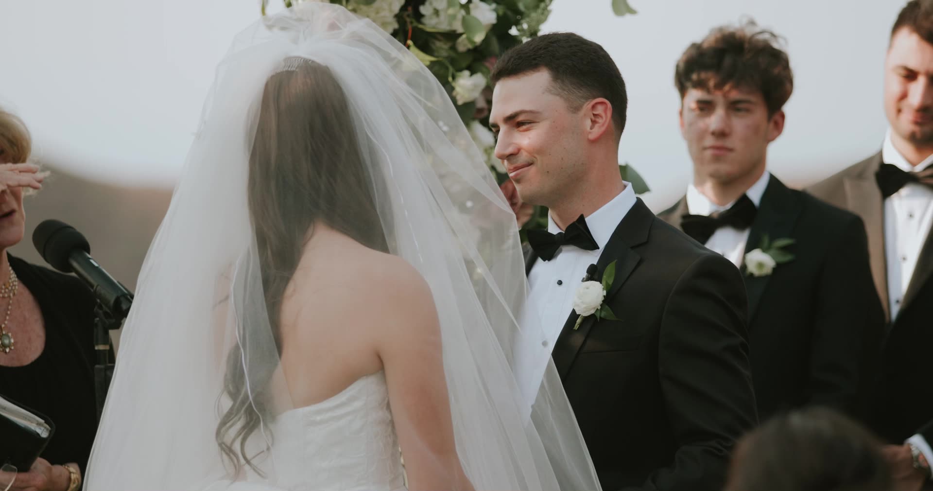 Alex and Leah at the altar beneath the floral arch at Cielo Farms