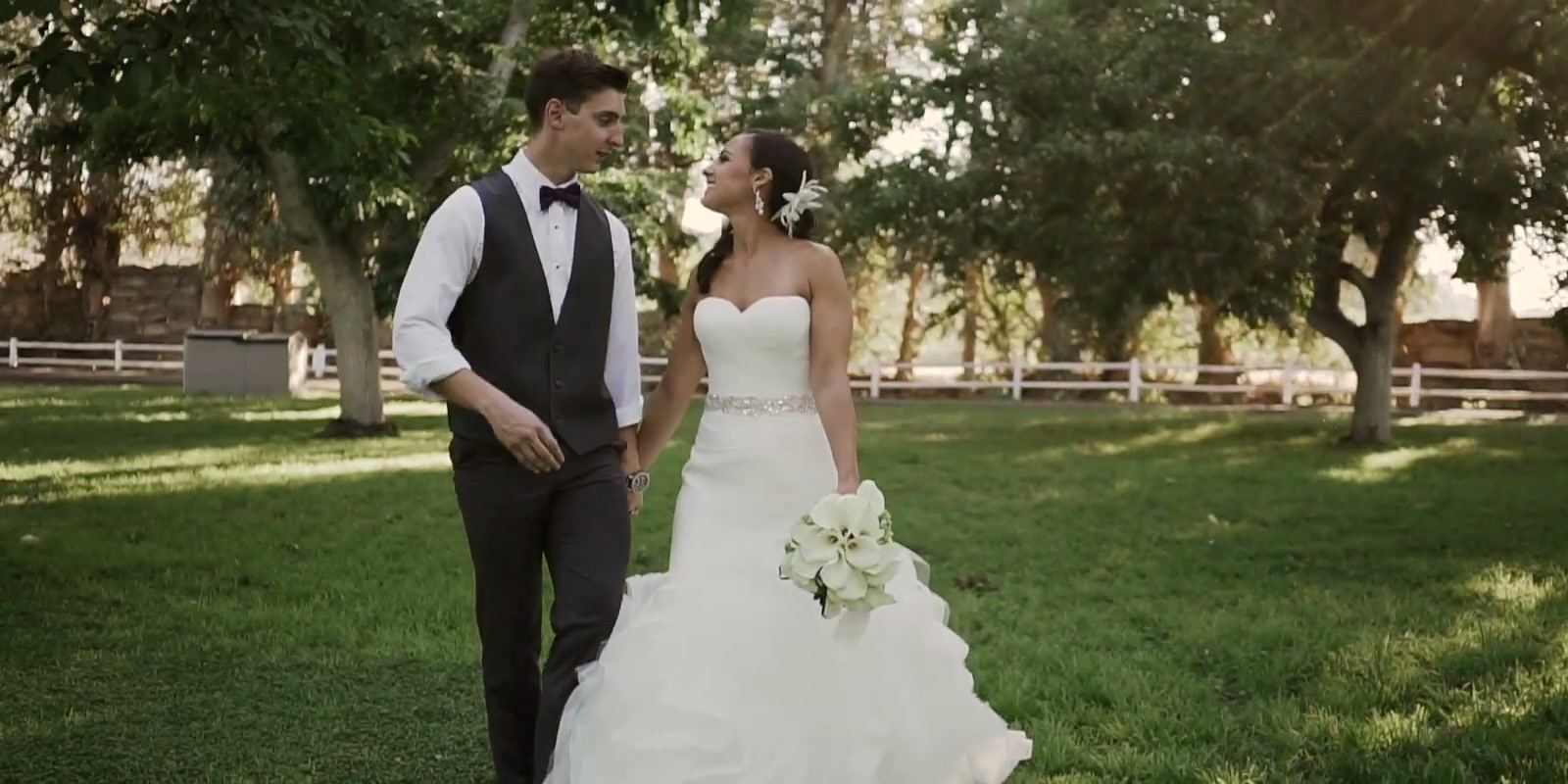 Alex and Lindsay walking hand in hand across the lawn under the walnut trees.