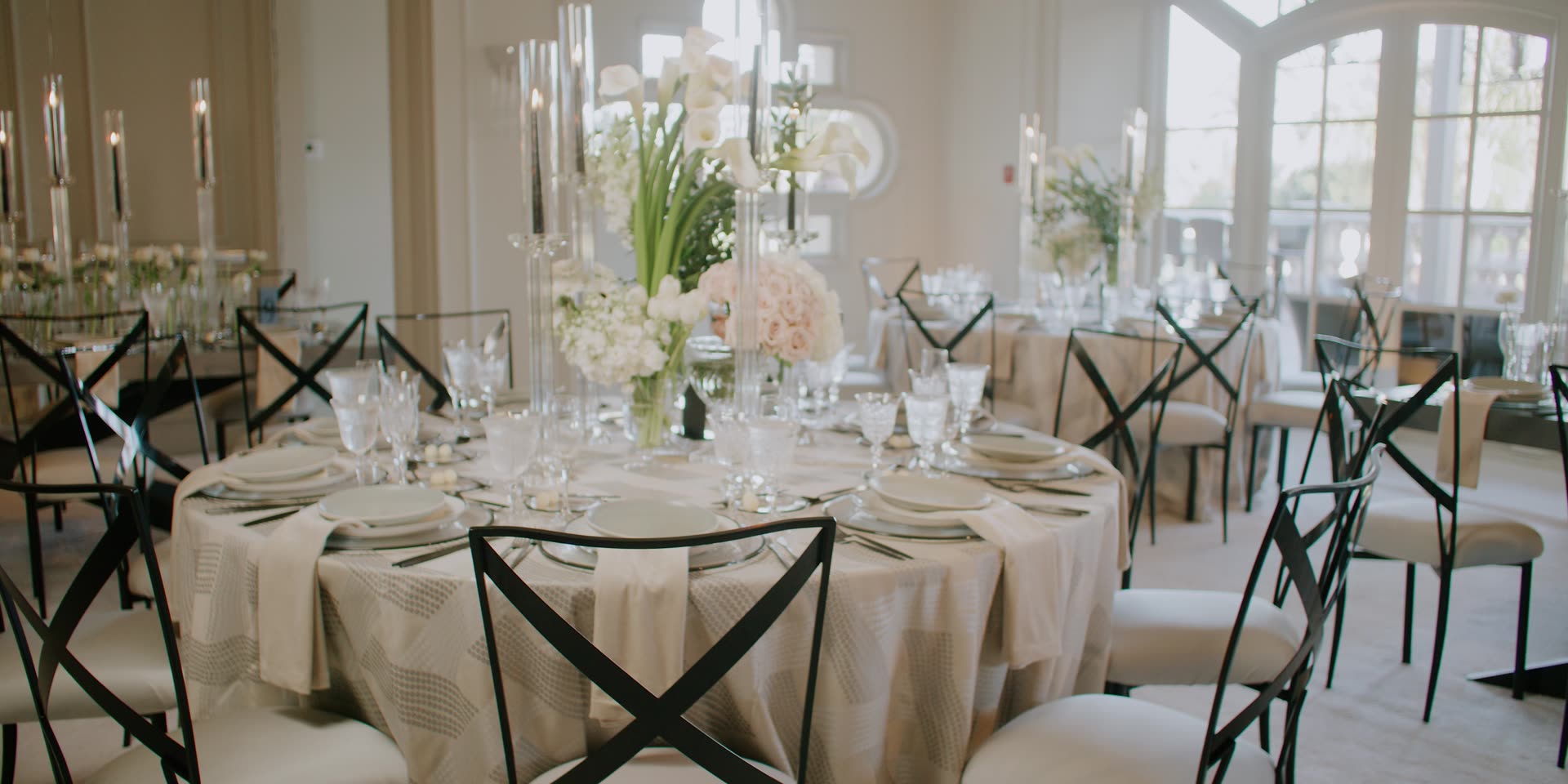 A reception table set with candles and white florals overlooking the ocean at The Ritz-Carlton, Laguna Niguel