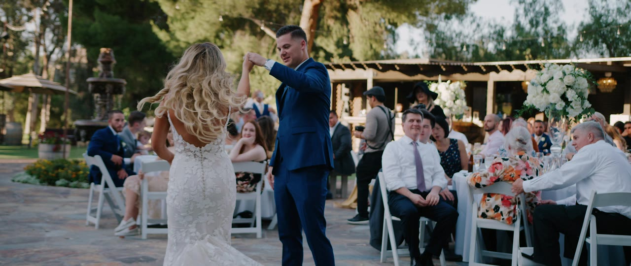 Brandon twirling Erin during their first dance on the stone patio at Lake Oak Meadows