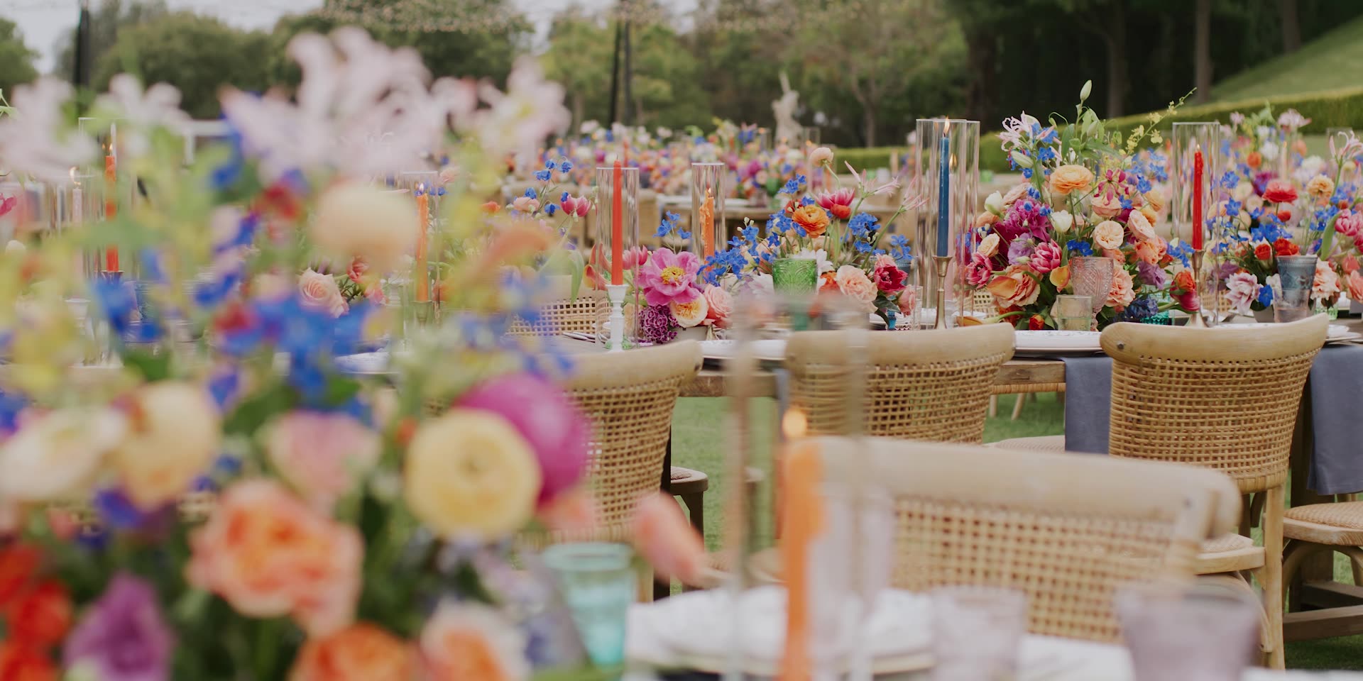 Reception tables set with vivid florals and coloured tapers in Carpinteria