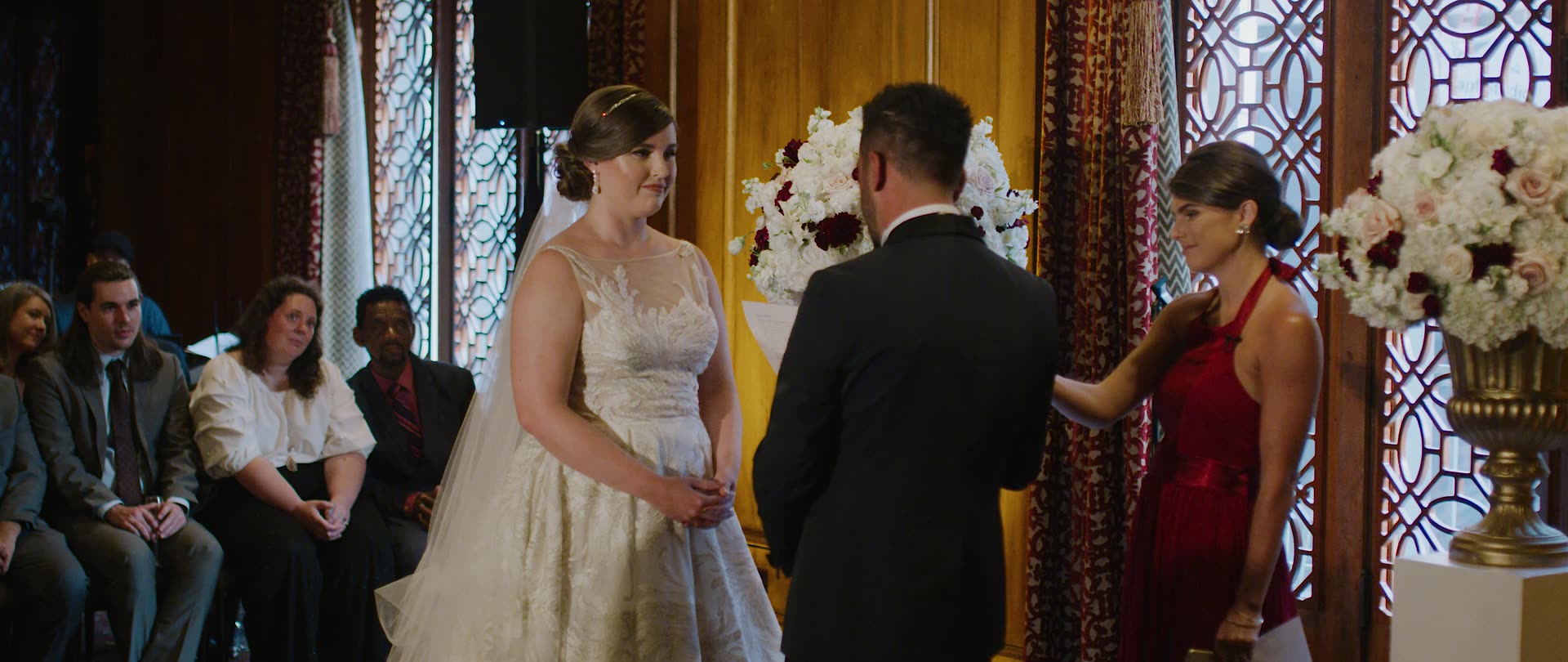 Bulent and Jessica at the altar beside the stained glass at the Los Angeles Athletic Club