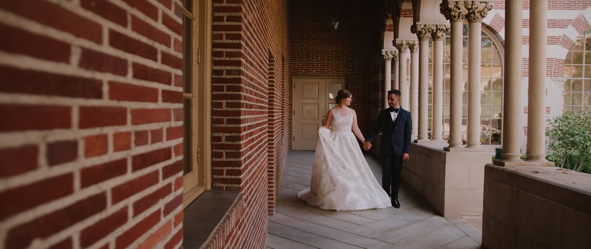 Bulent and Jessica walking the brick colonnade downtown before the ceremony
