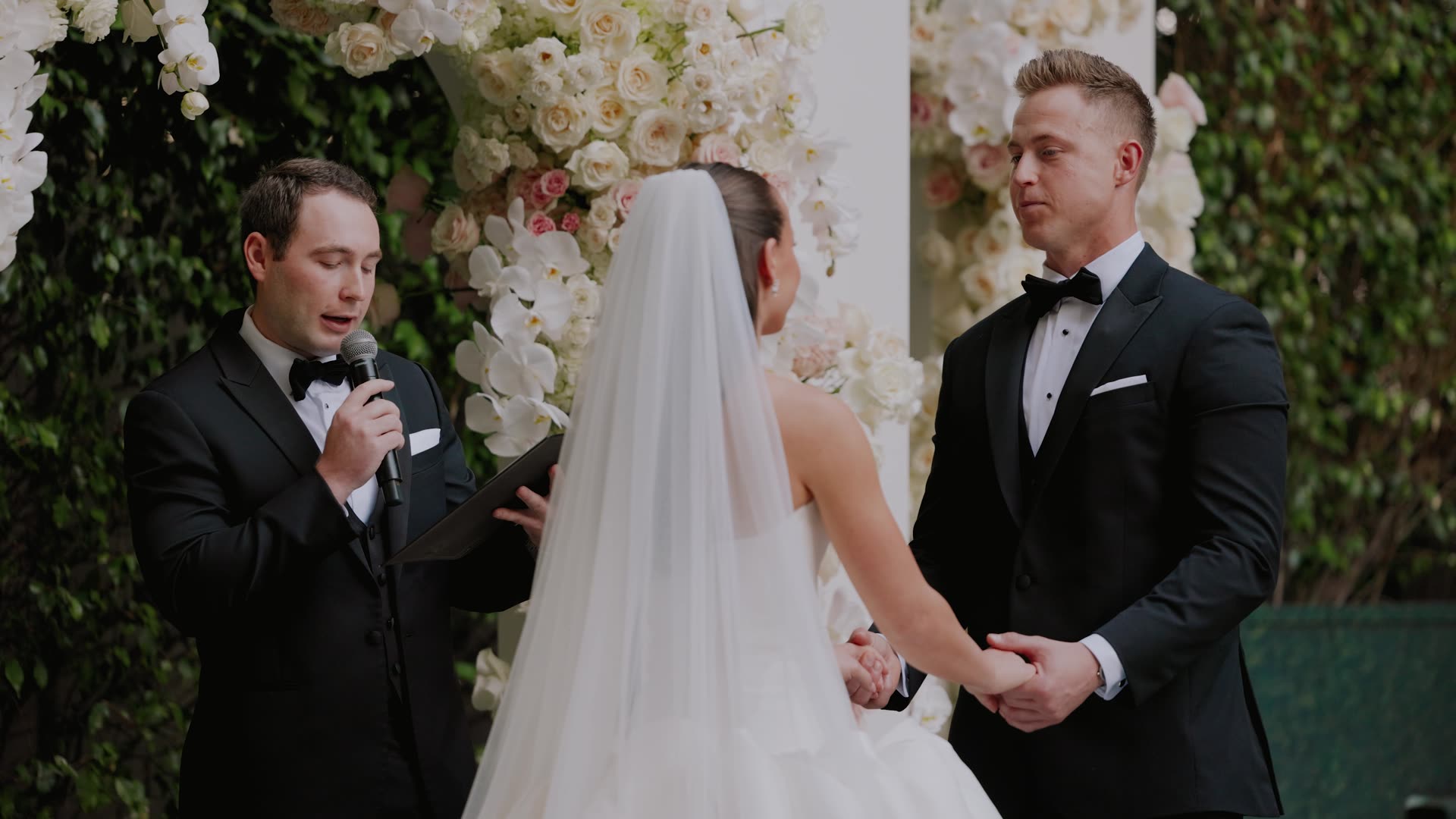 Brian and Ryan at the altar beneath a white floral arch at Four Seasons Los Angeles