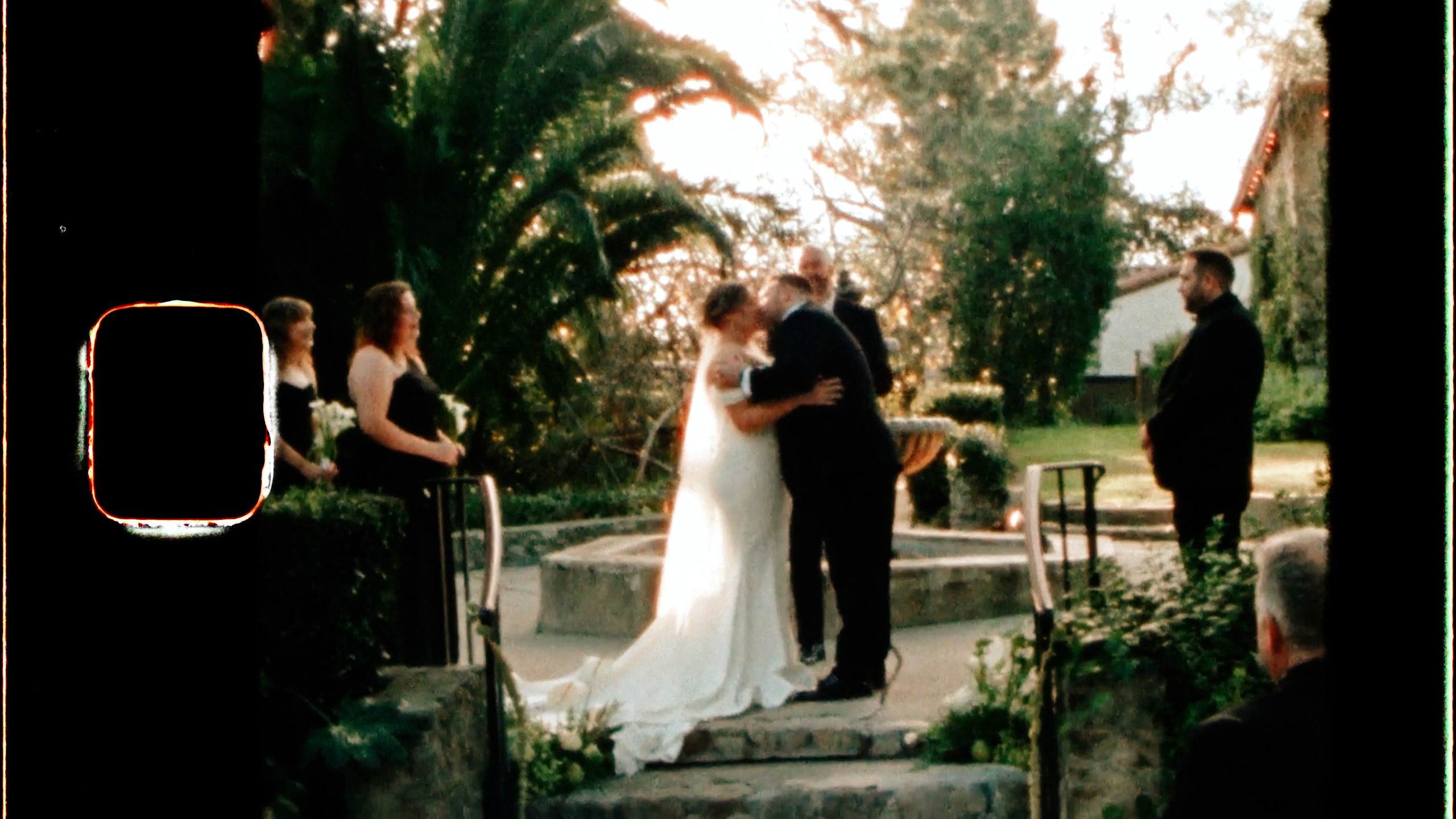 Chris and Emily's first kiss on the fountain steps at Hidden Oaks Retreat Center, shot on Super 8