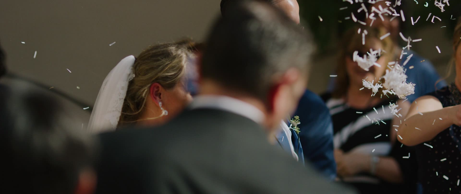 Chloe and Francis walking out through confetti after the ceremony at The Athenaeum