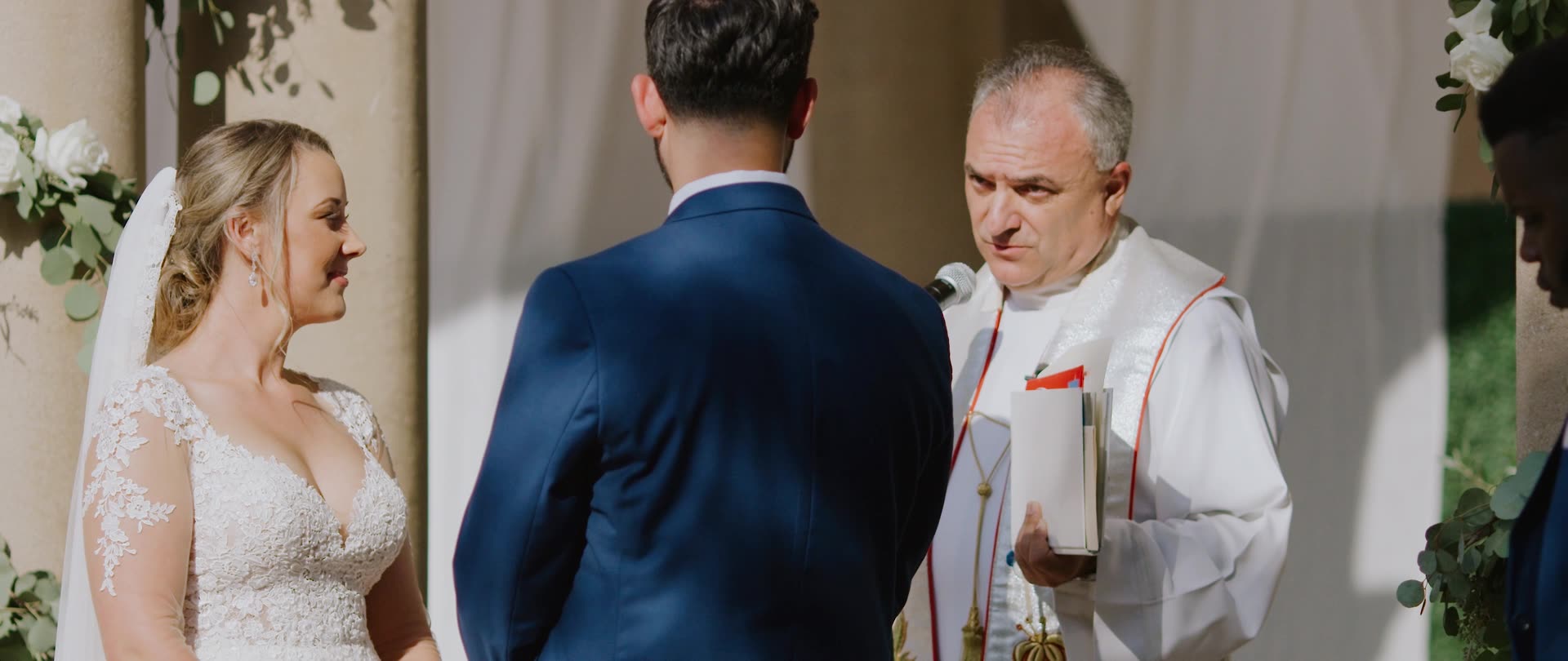 Chloe and Francis exchanging vows beneath the colonnade at The Athenaeum