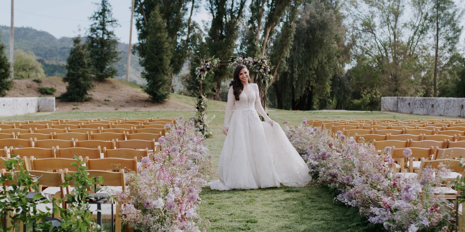Jocelyn on the ceremony lawn, the aisle lined with lavender and the Ojai mountains beyond, at Ojai Valley Inn