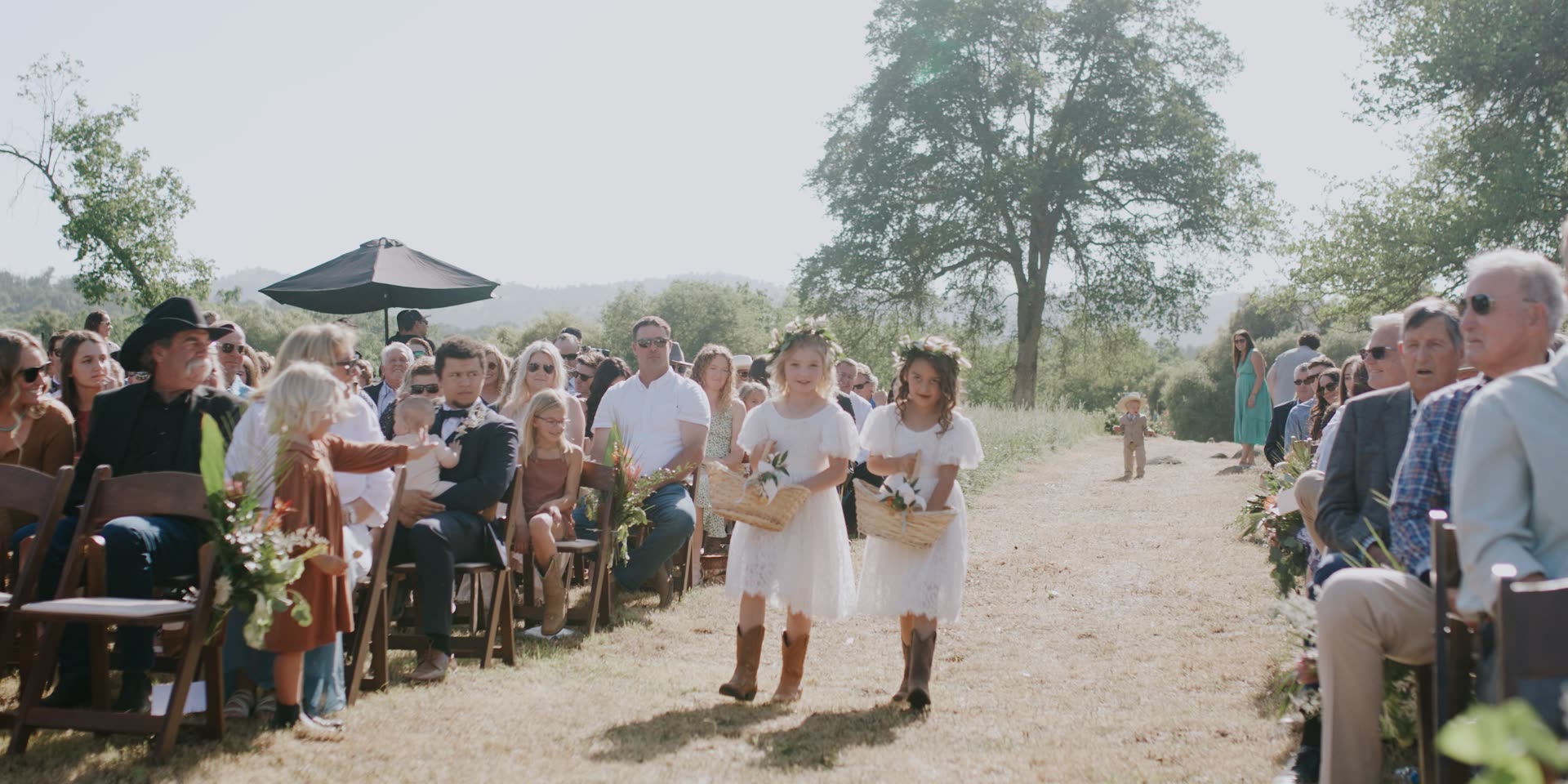 The flower girls coming down the aisle beneath the oaks in Kingsburg