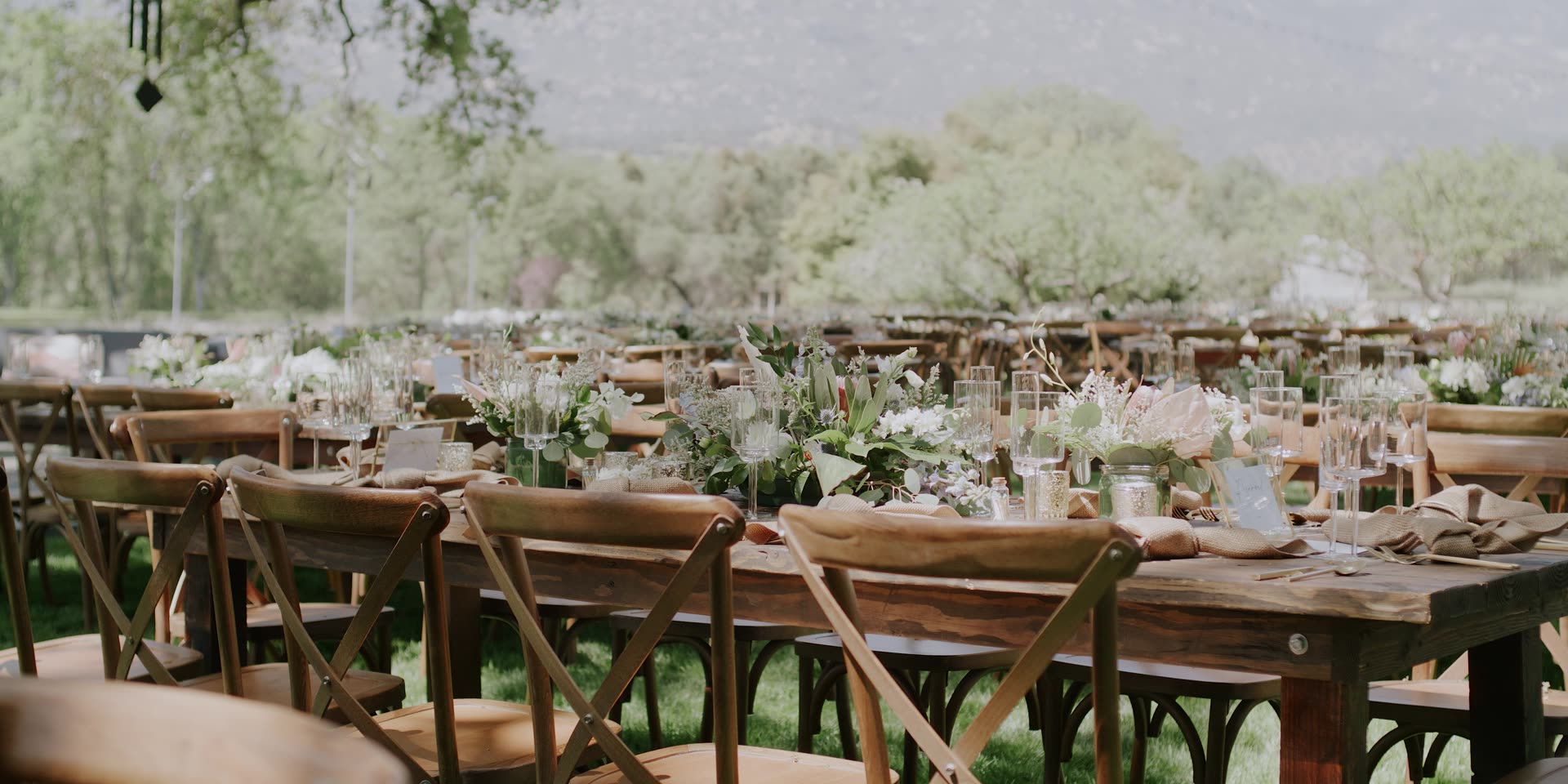 Long wooden farm tables set for dinner beneath the oaks in Kingsburg