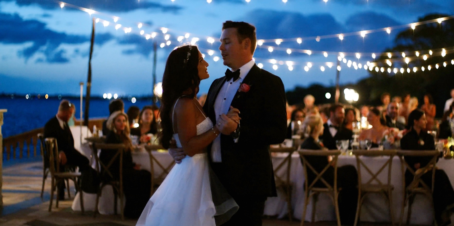 First dance under string lights on the bayfront terrace at a Ca d'Zan wedding in Sarasota, Florida