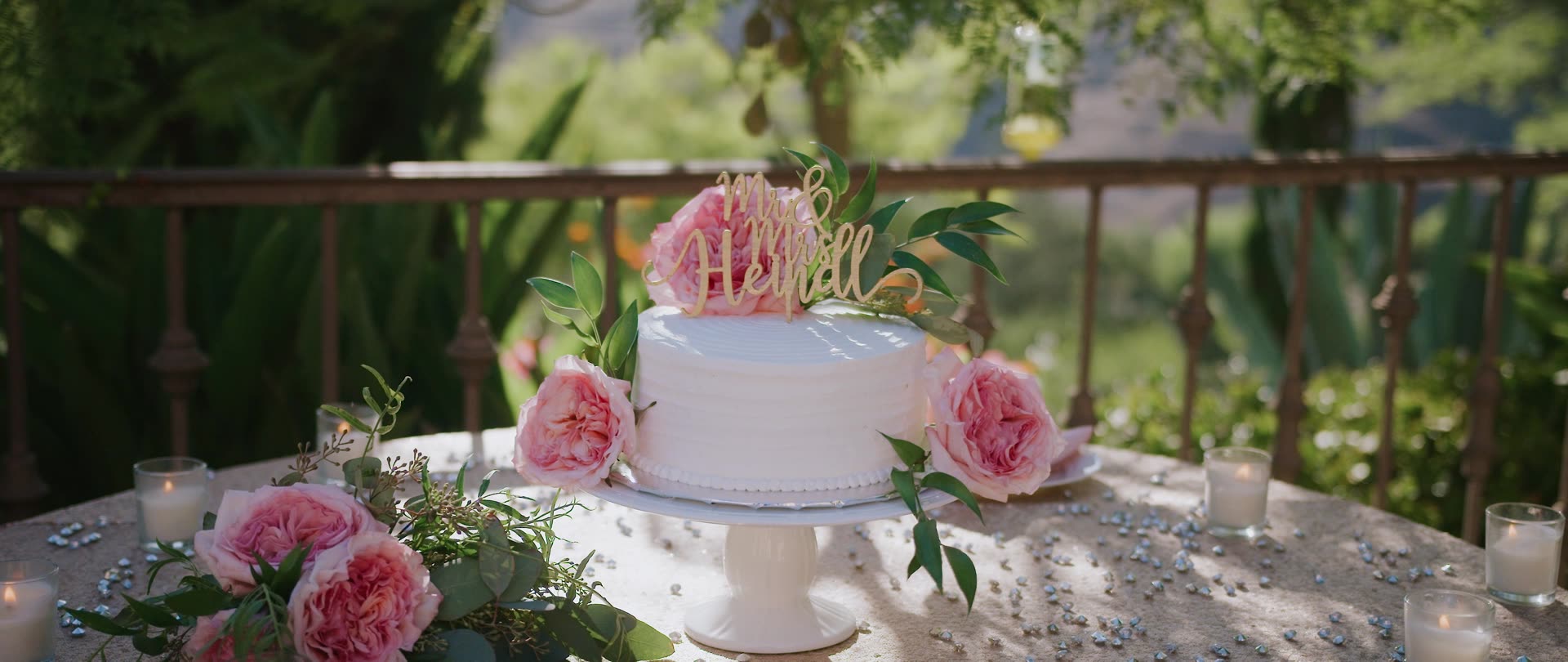 The cake set out with pink peonies on the balcony at Villa Verano
