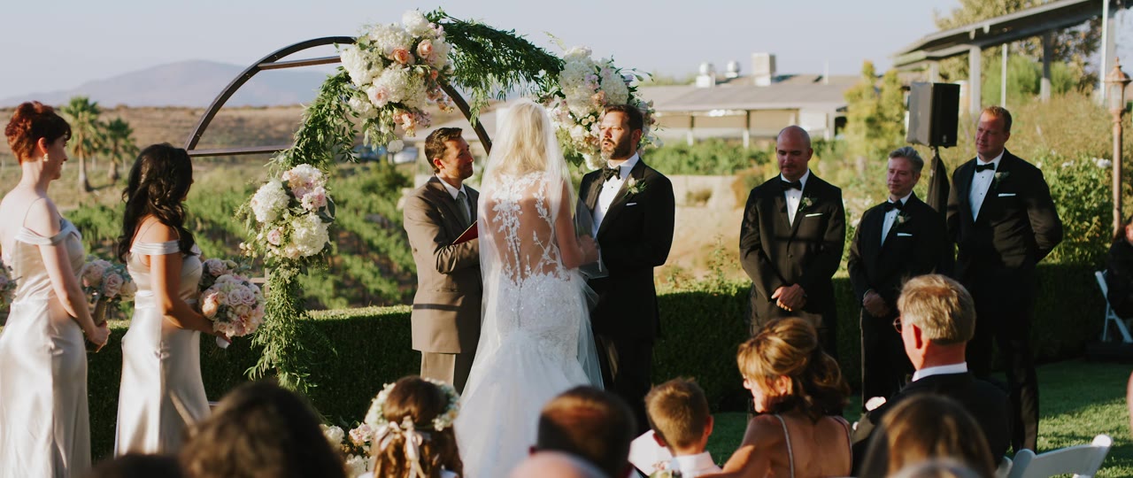 Eric and Analise's ceremony under the floral arch above the vines at Callaway Winery