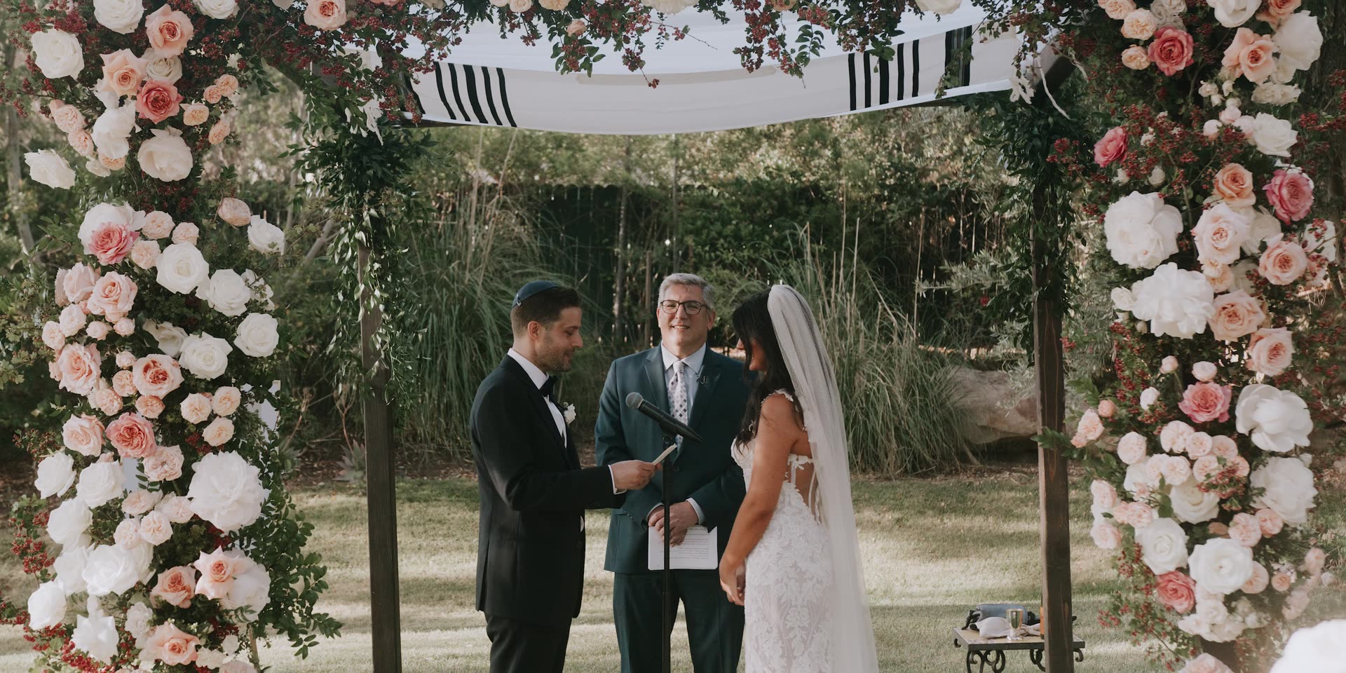 Evan and Kelly's ceremony beneath a chuppah of blush and white roses at Hummingbird Nest Ranch