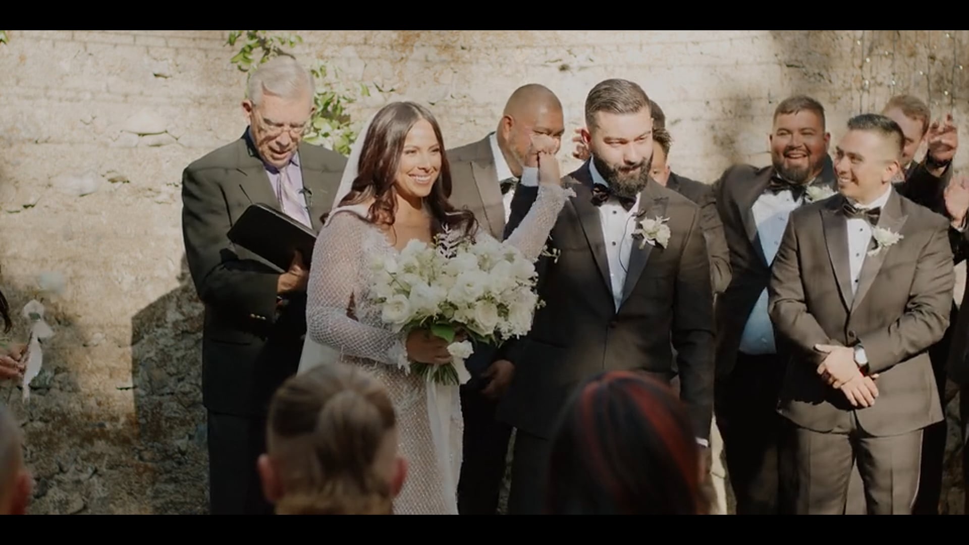 Anthony and Gabi at their wedding ceremony against a stone wall in Calistoga, California