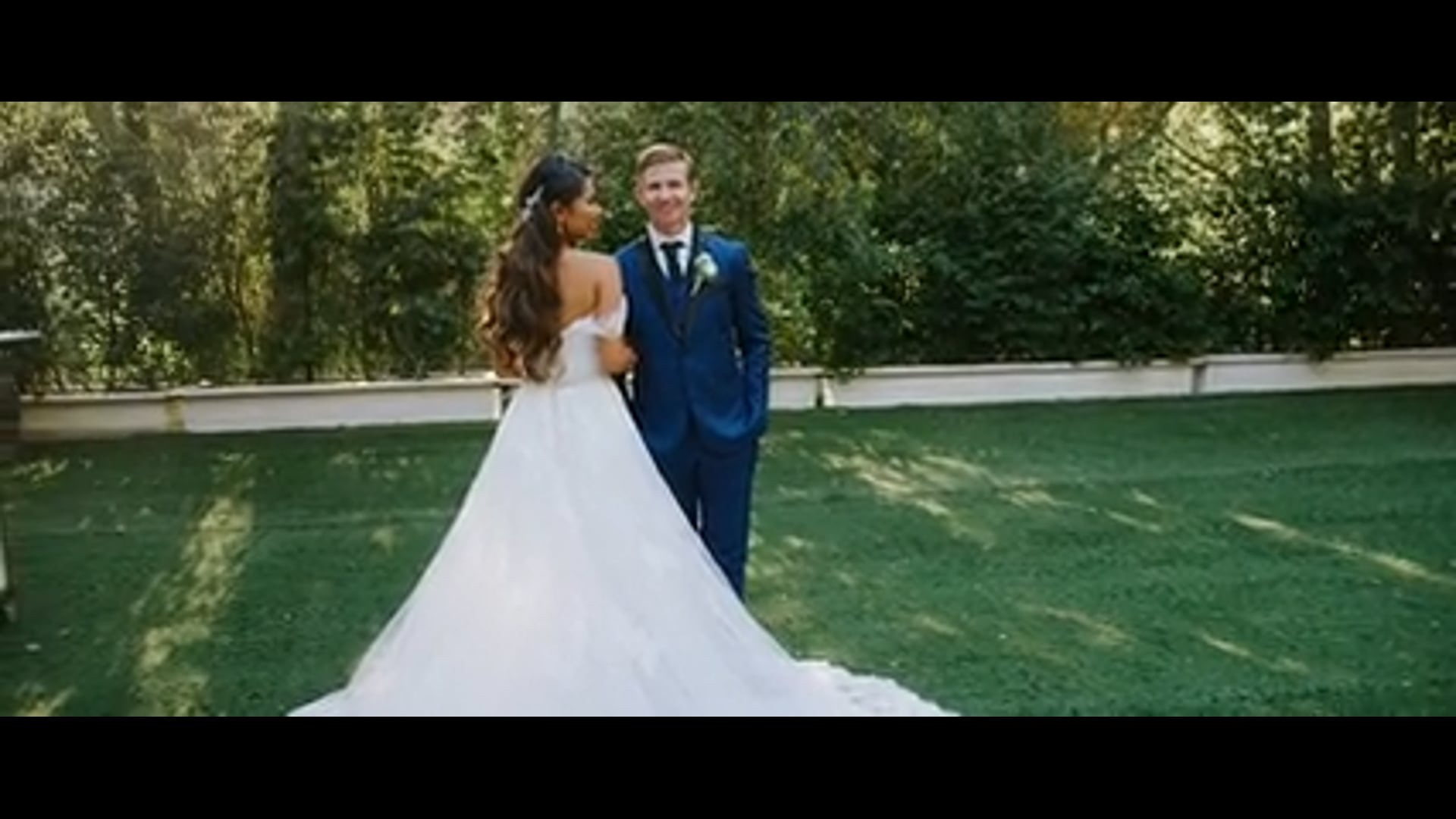 Ben and Catherine walking together on the lawn at Calamigos Ranch