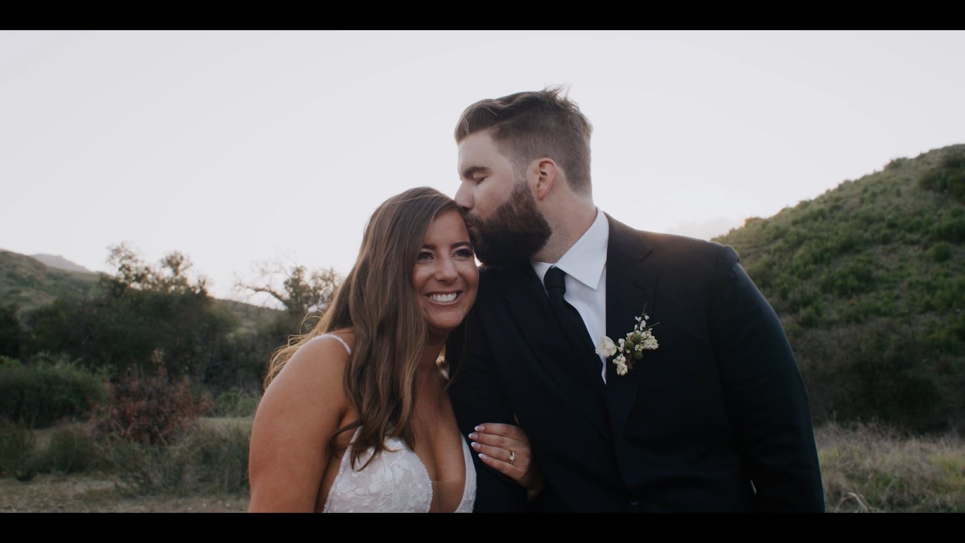 Brenden and Jenna sharing a kiss on the hillside at Bel-Air Bay Club