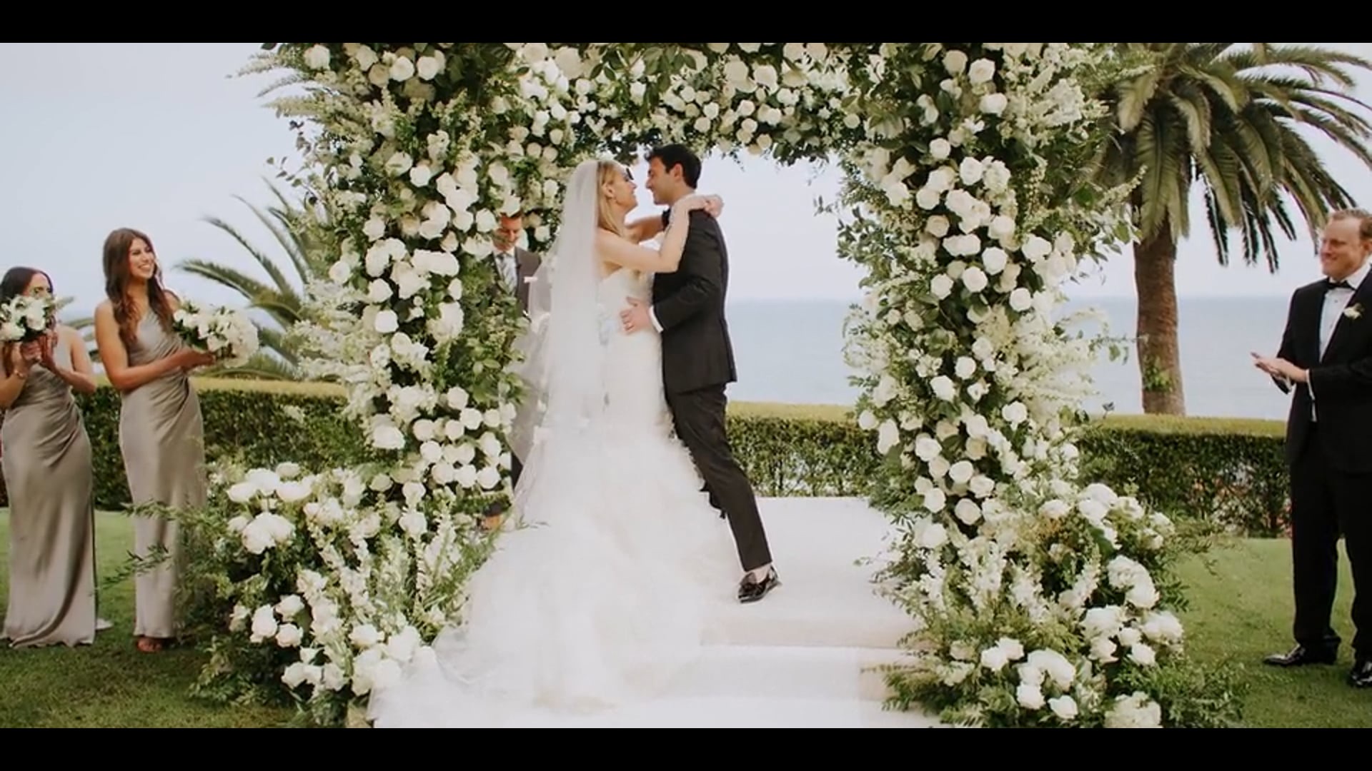 Brennan and Meghan's first kiss under a floral arch at Bel-Air Bay Club