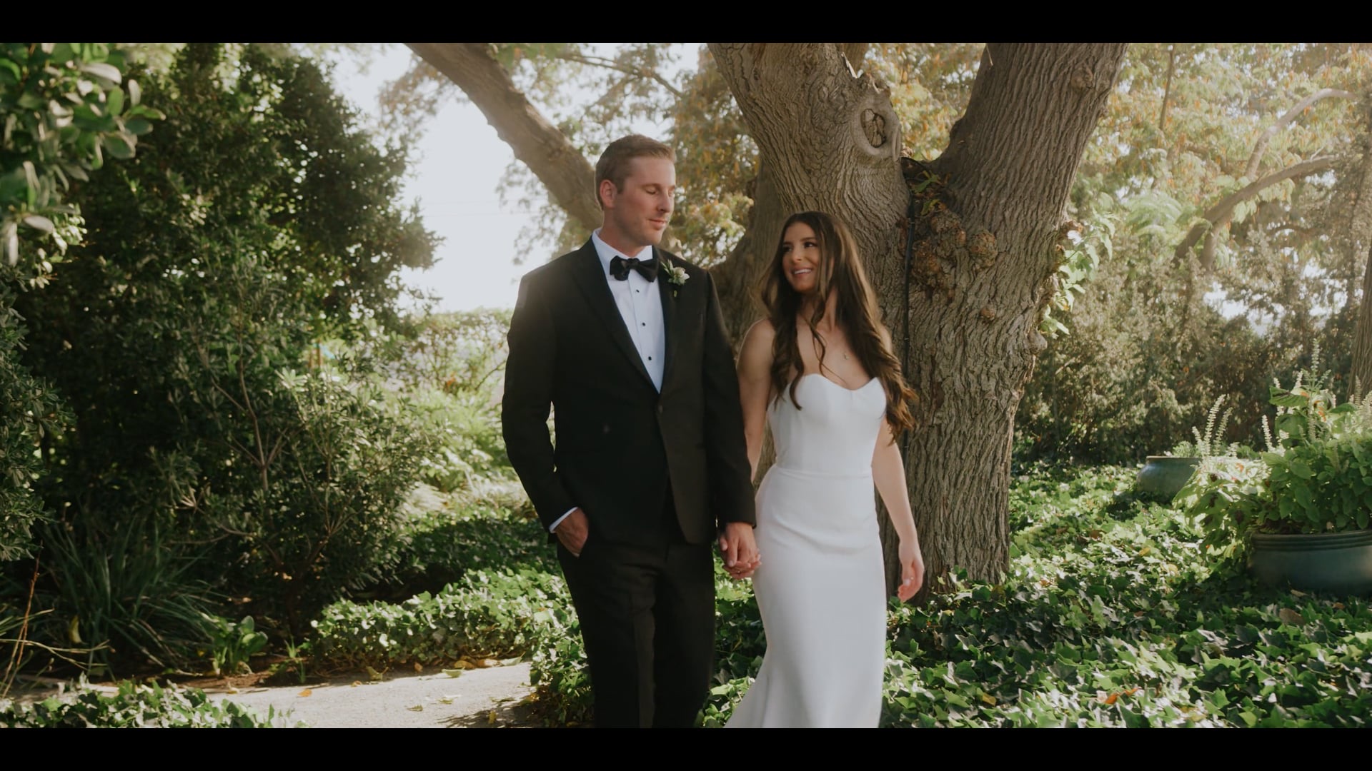 Donnie and Danae walking hand in hand under the oak on their wedding day in Kingsburg, California