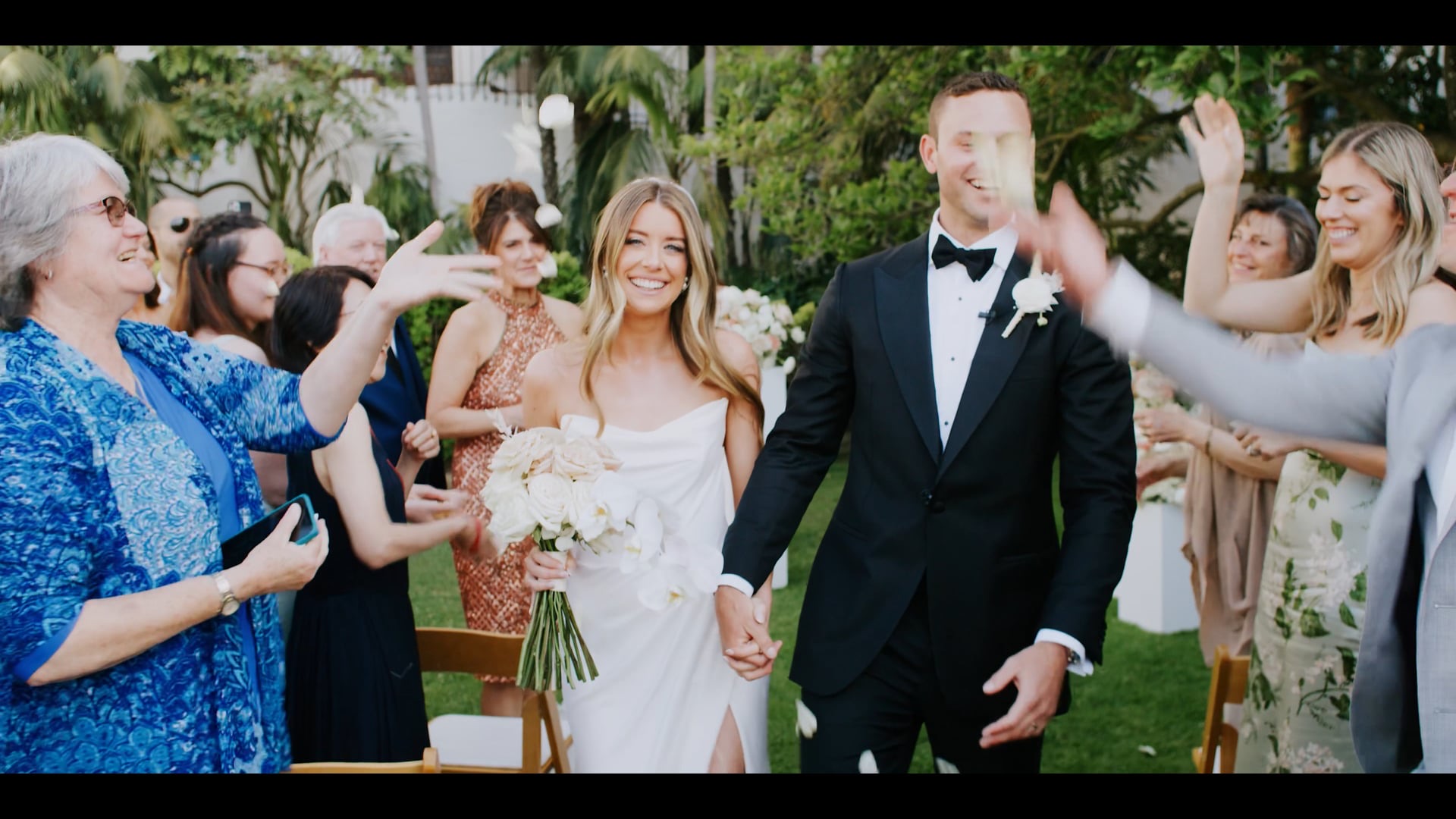 Erik and Julianna walking their recessional through falling petals at the Santa Barbara Courthouse