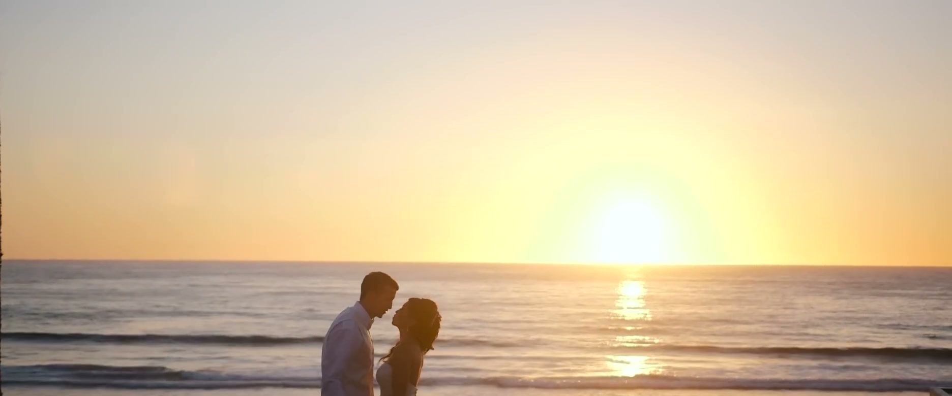 Gina and Jeff at the waterline, the sun low on the horizon behind them