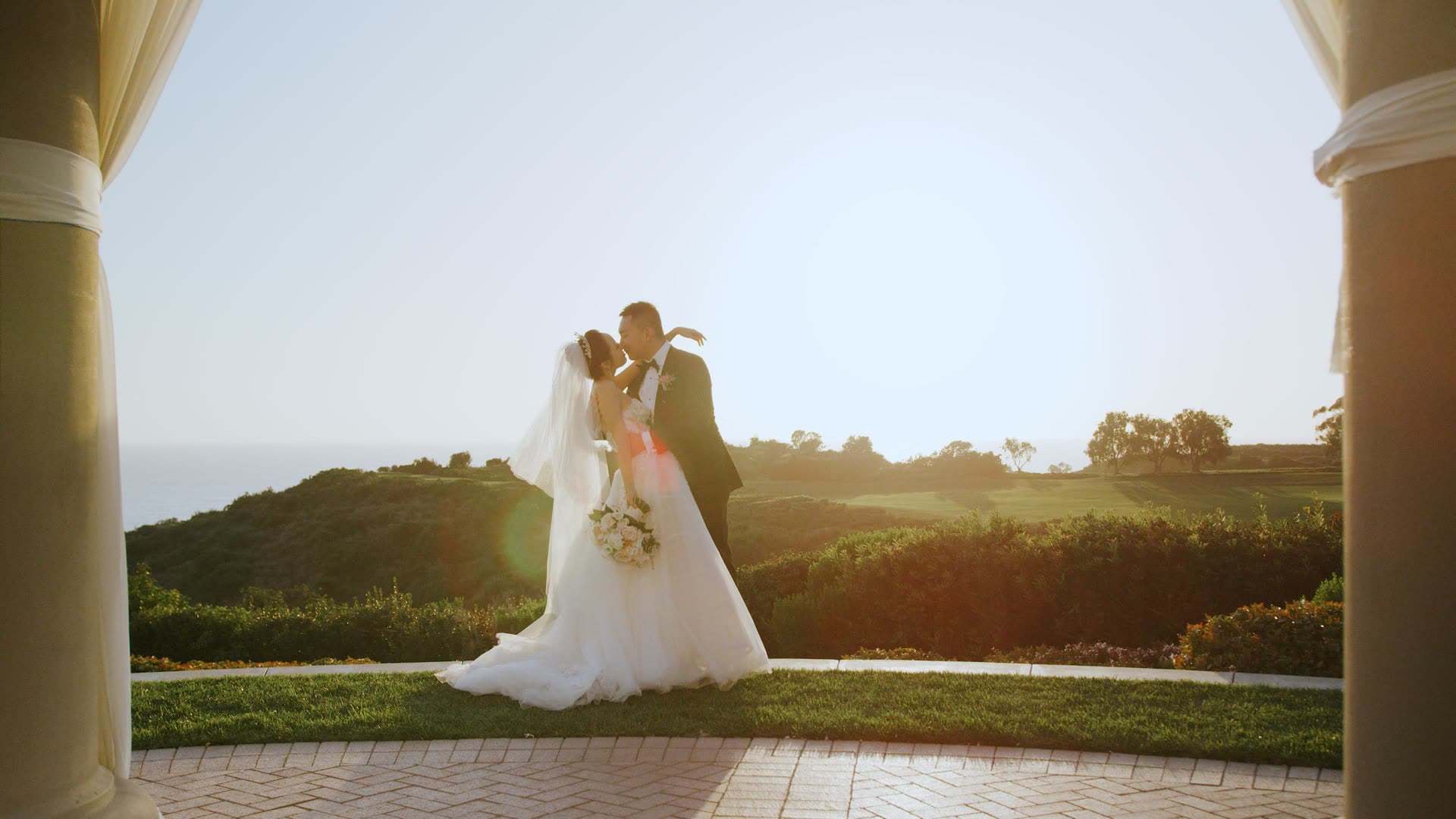 Jerry and Mia framed by the colonnade of the rotunda at Pelican Hill with the Pacific behind them