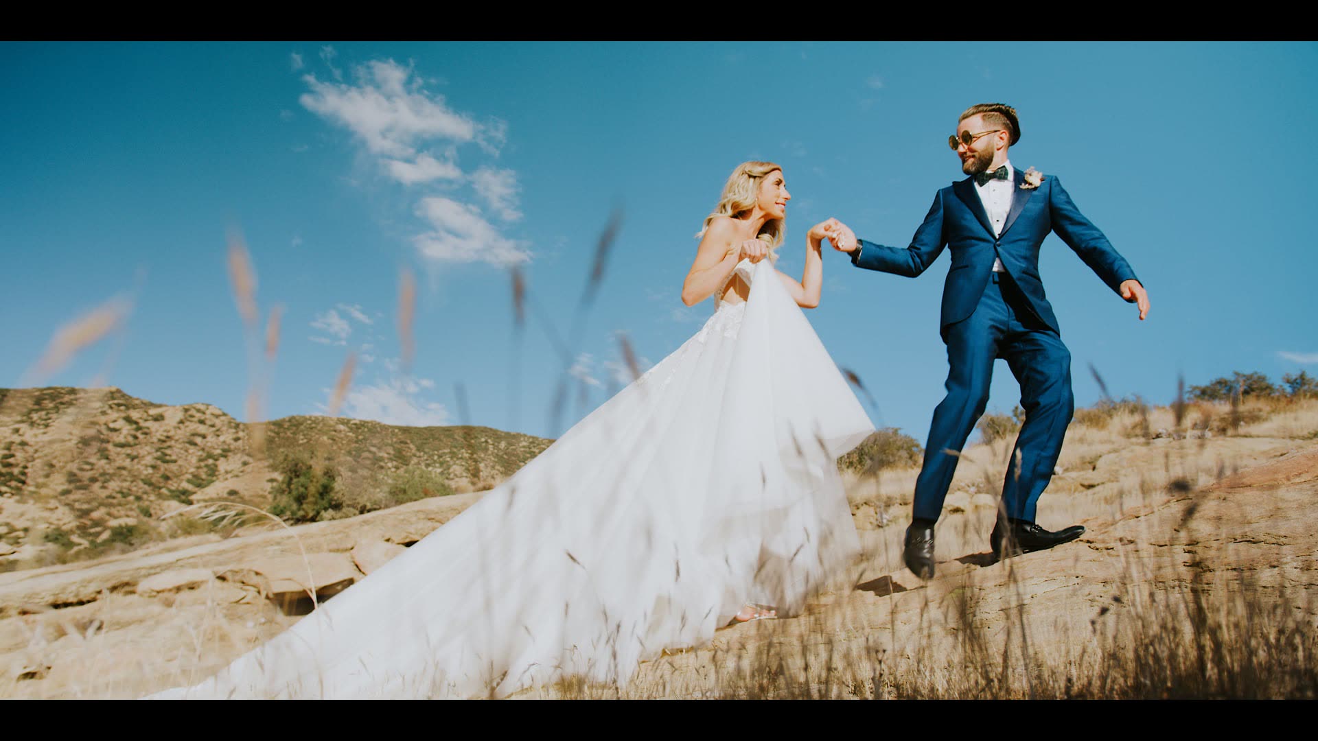 Marcel and Lauren walking together across the open hillside at Hummingbird Nest Ranch