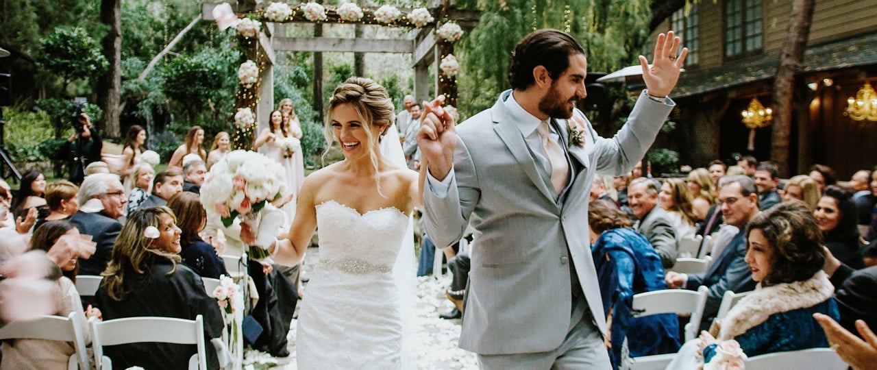 Mariah and Joey walking back down the aisle through their guests at Calamigos Ranch