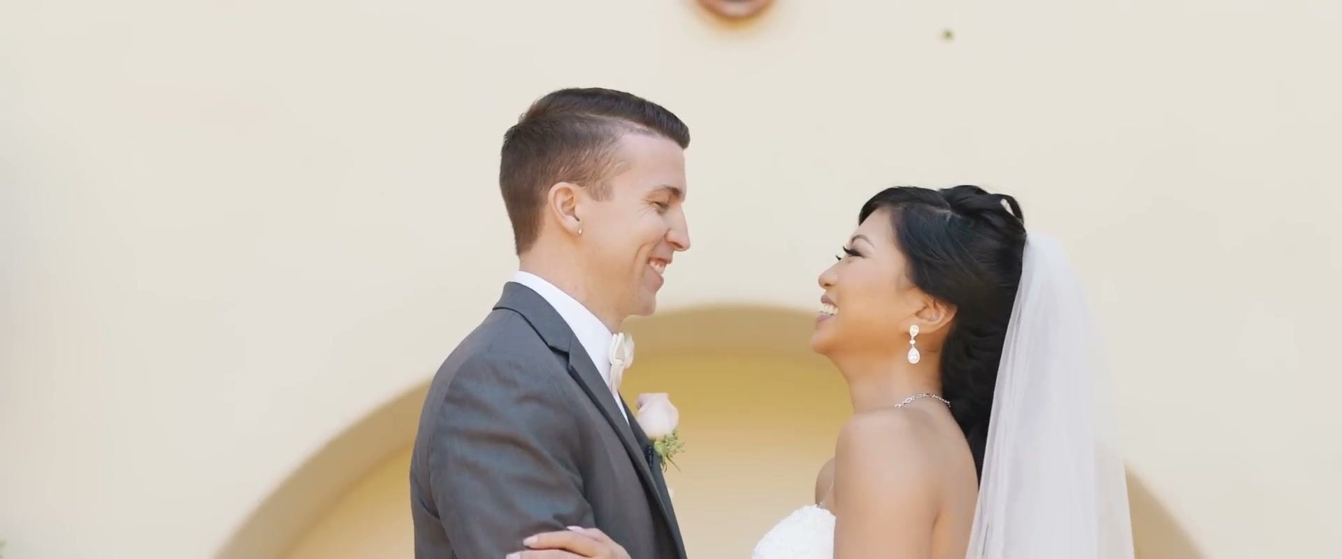 Gina and Jeff face to face and laughing in front of a cream stucco wall with an arched alcove.