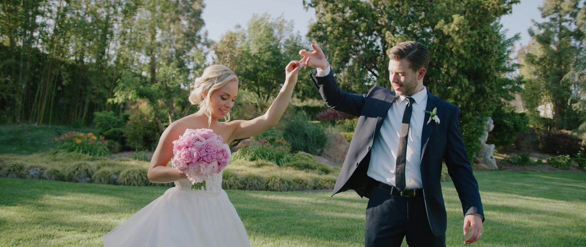 Garrison turning Meredith under his arm on the lawn, her pink bouquet still in her free hand.