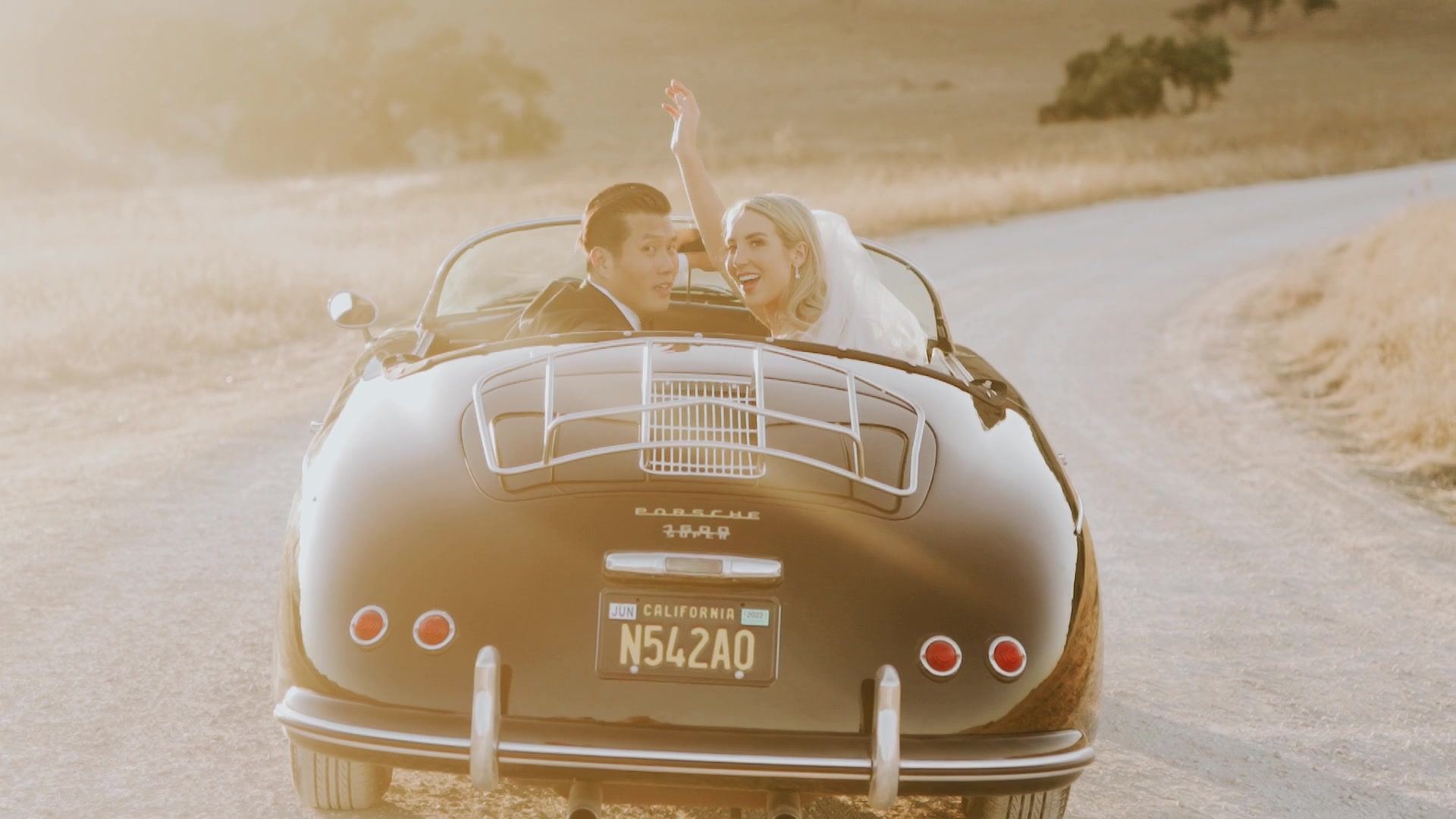 The vintage convertible pulling away down the dirt road with the two of them in it, the hills gold on either side.
