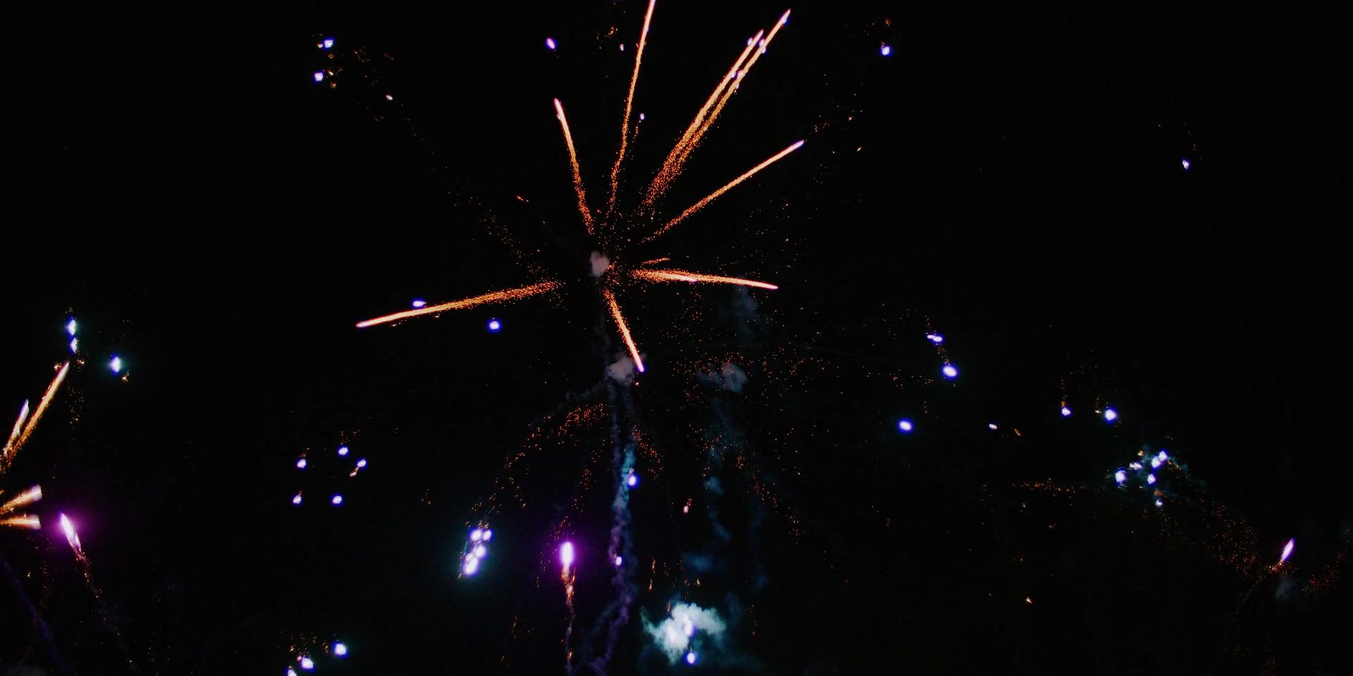 Fireworks bursting against a black sky.