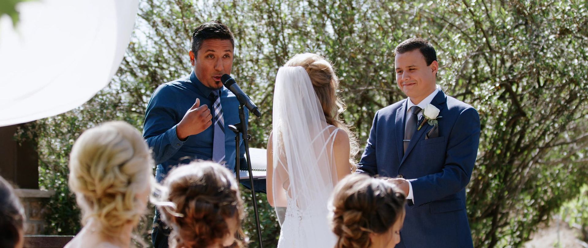 The ceremony, Jonathan and Breanna facing each other as the officiant speaks.