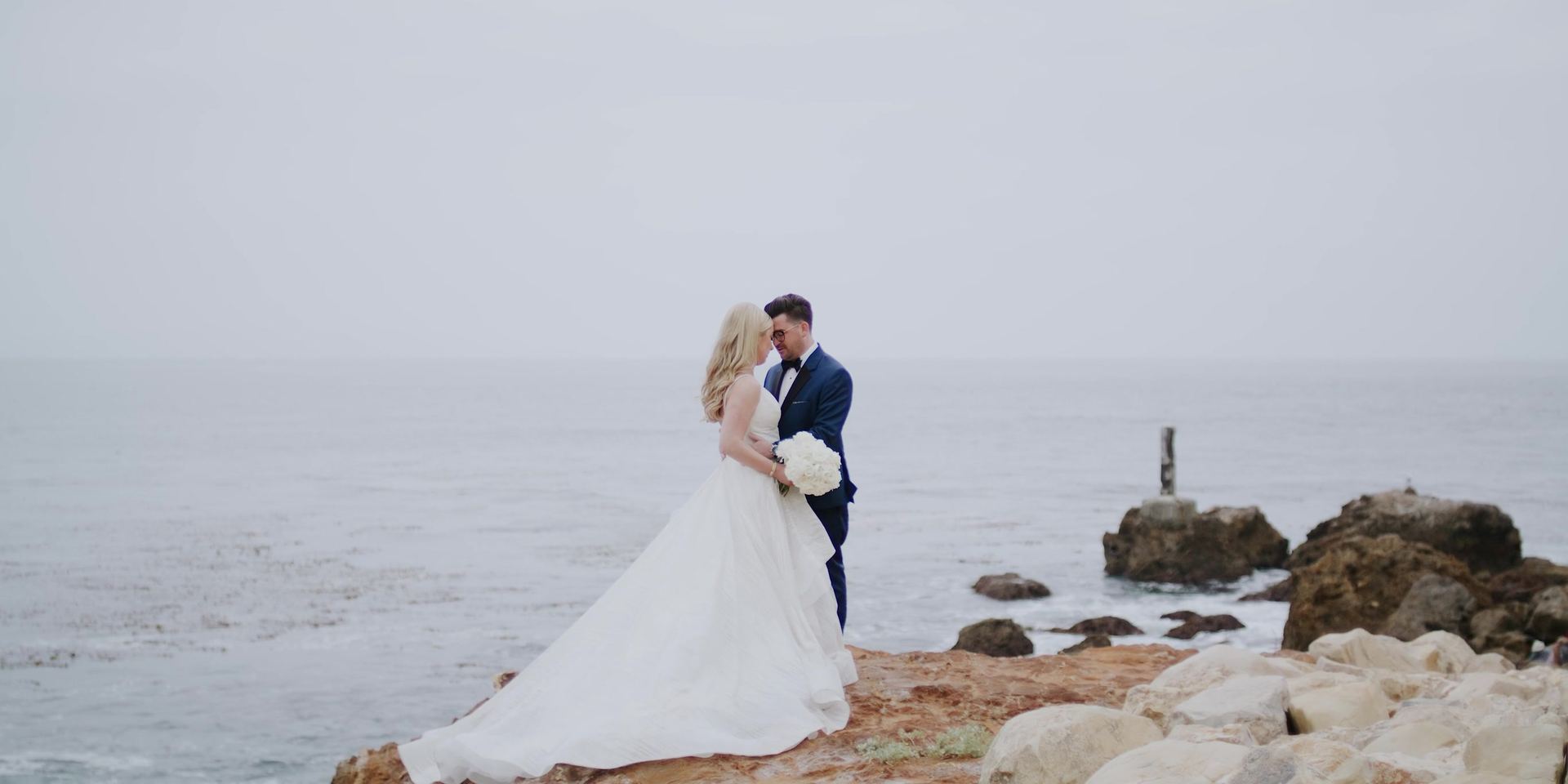 Josh and Gina on the rocks at the waterline below Terranea Resort