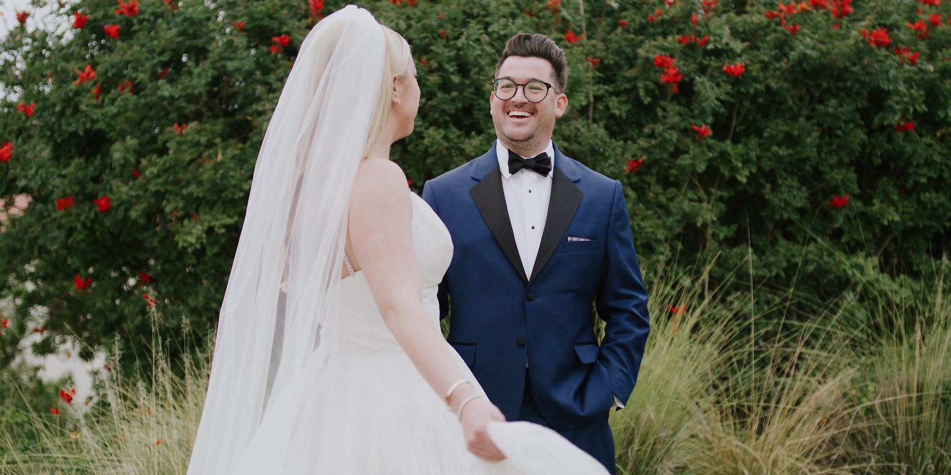 Josh and Gina in front of a hedge of red blooms at Terranea Resort