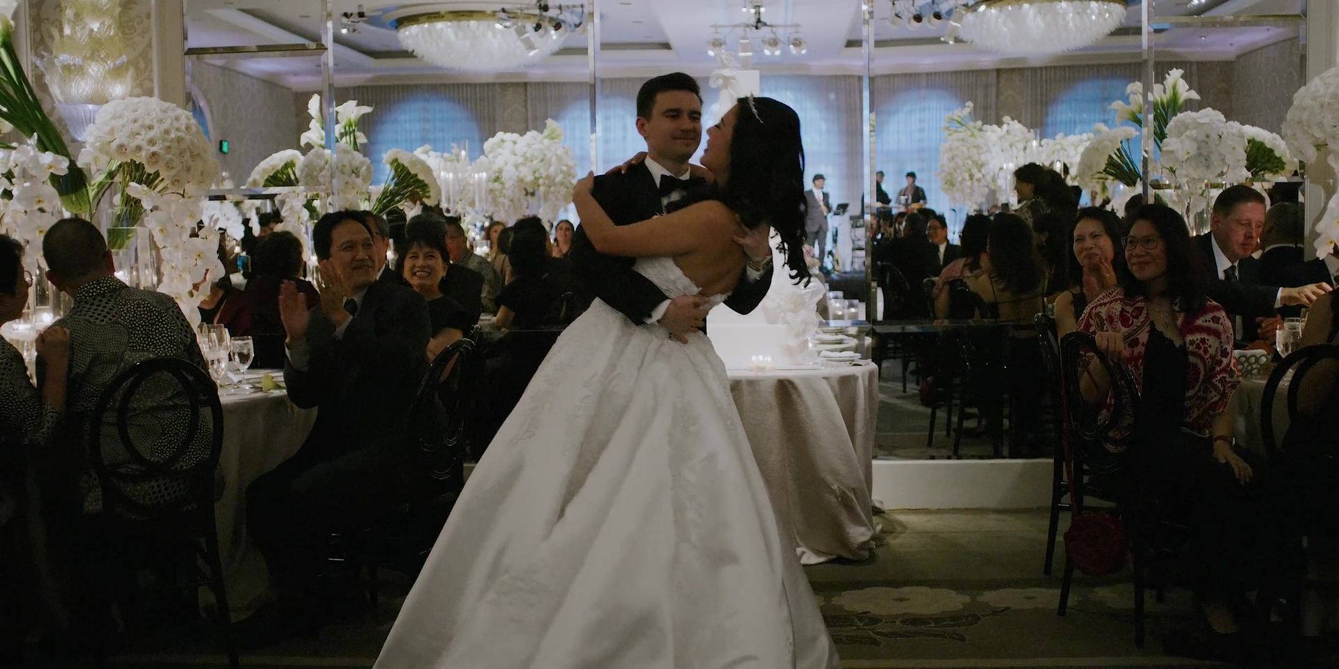 Joe and Jessica's first dance, orchids banked behind them.