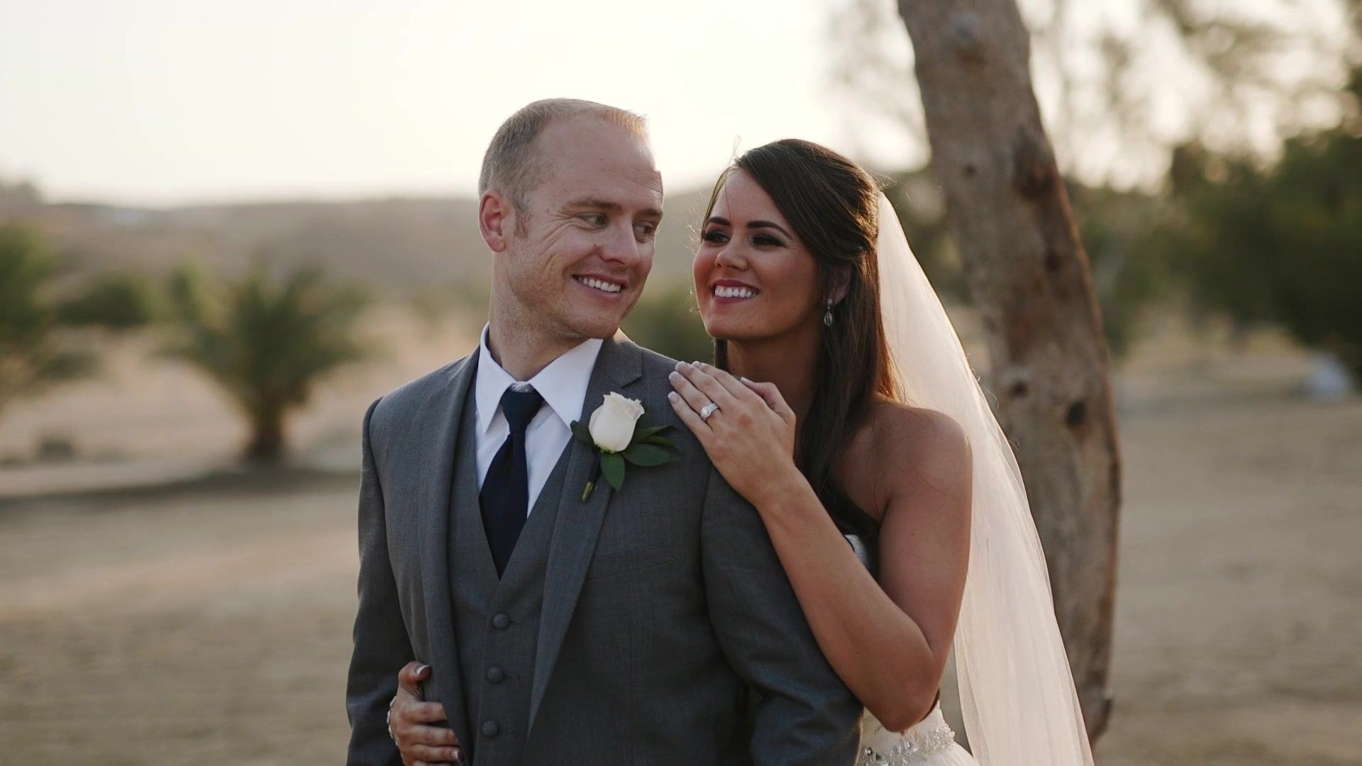 Josh smiling at Jade beneath a eucalyptus, her hand on his chest, her ring catching the light.