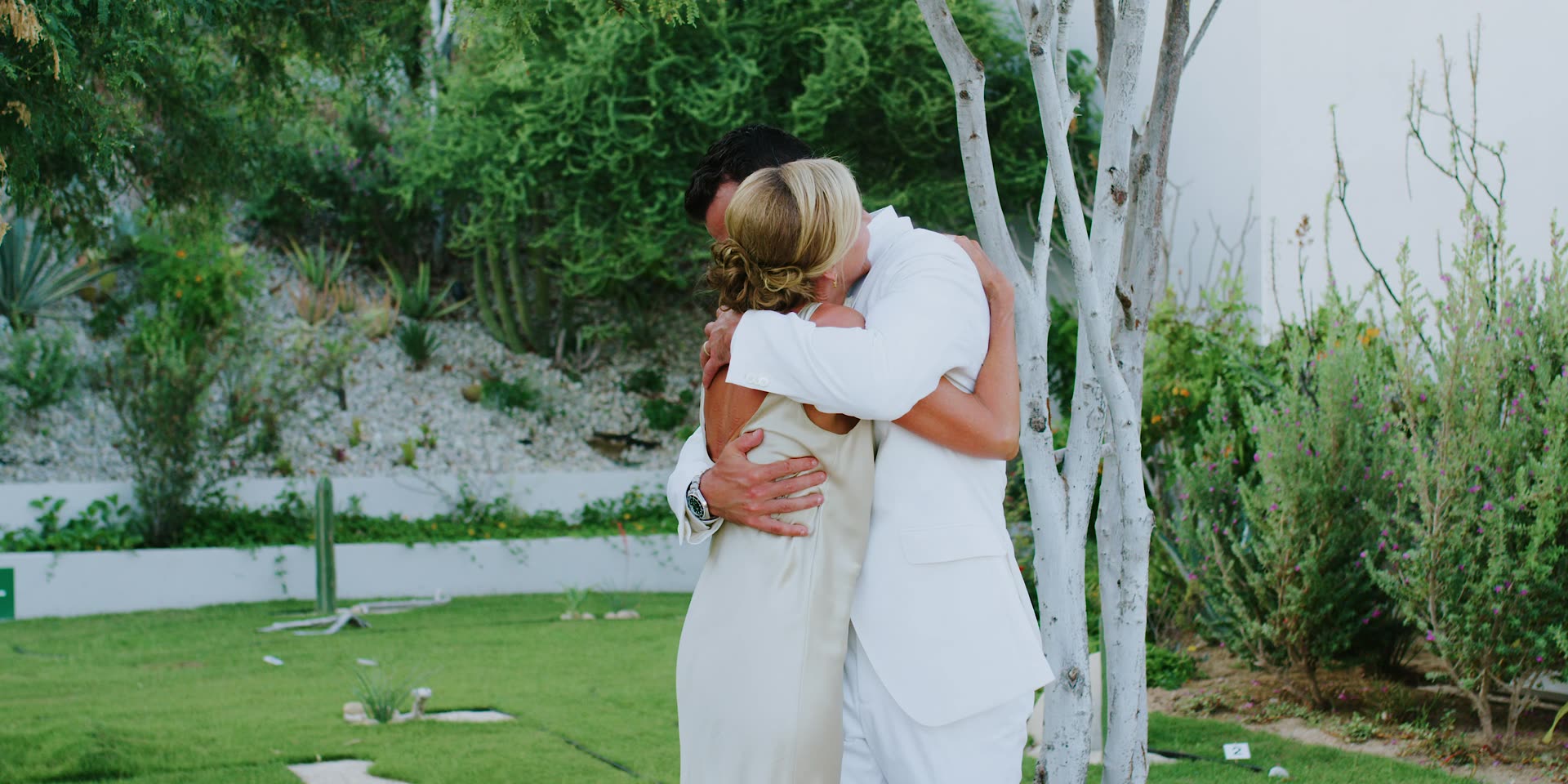Justin and Kelsey holding each other on the lawn in Los Cabos