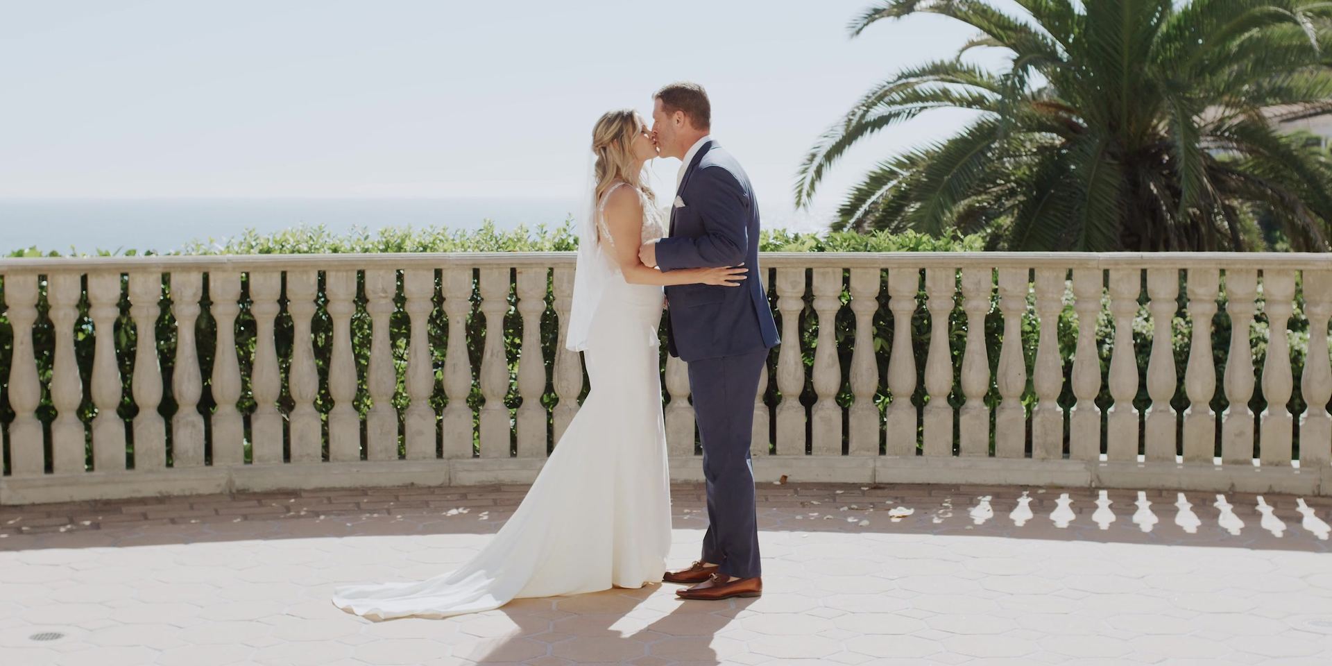 Justin and Mimi kissing at the balustrade above the ocean at the Bel-Air Bay Club