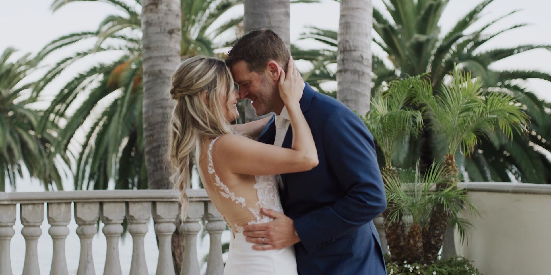 Mimi holding Justin's face, foreheads together beneath the palms at the Bel-Air Bay Club