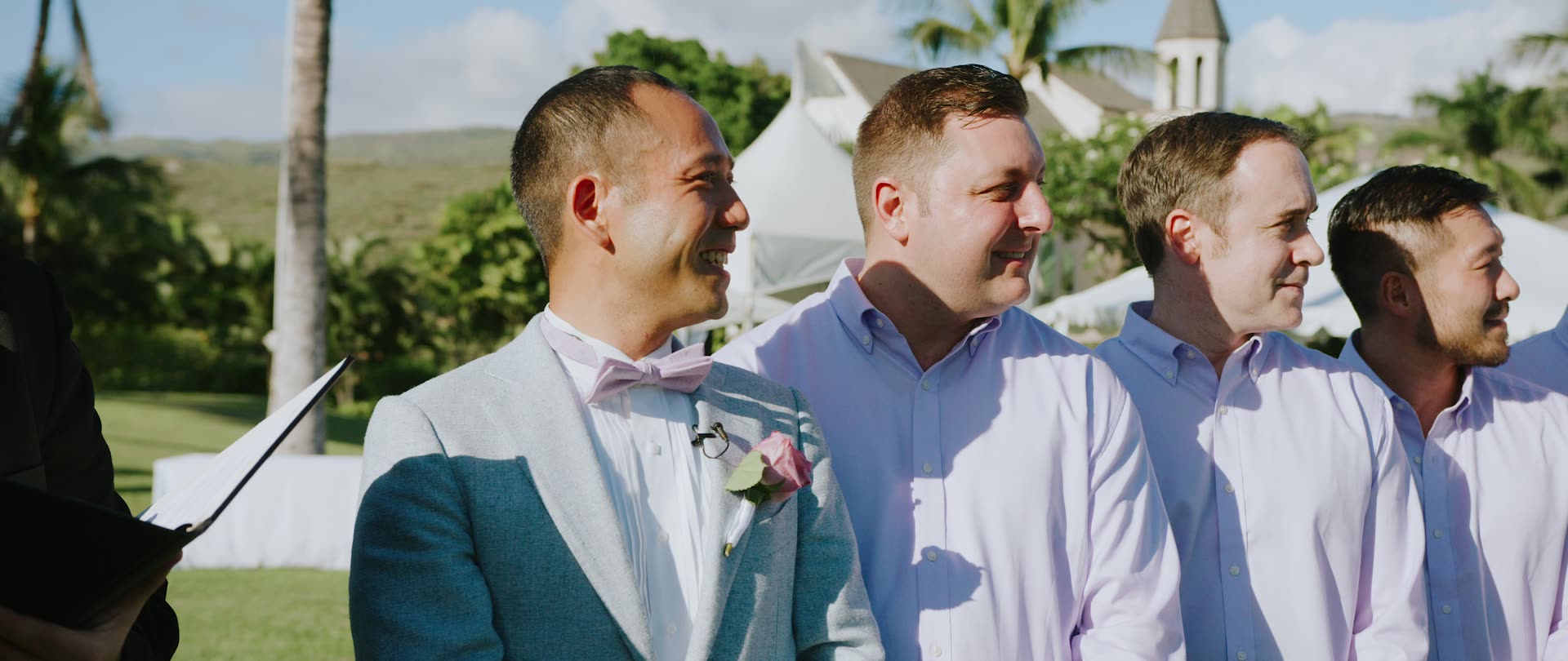 Zi and his groomsmen on the lawn at Paradise Cove with the Oahu mountains behind