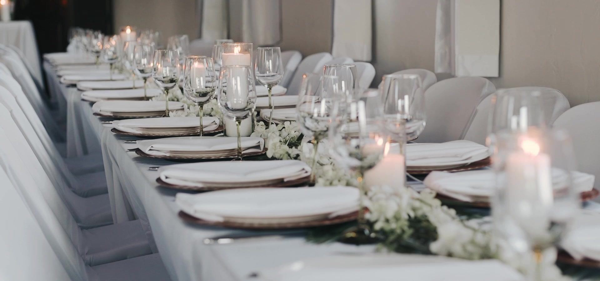The long reception table set with candles and low greenery running its length.