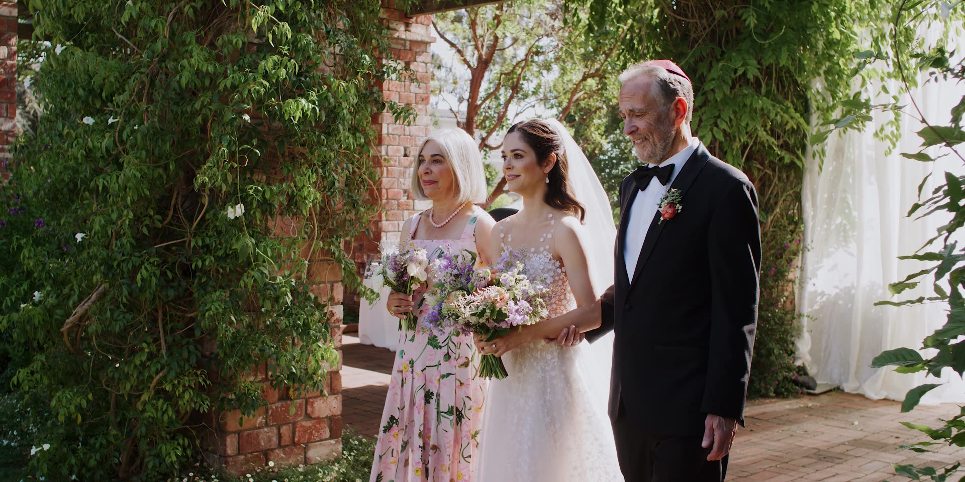 Maya with her parents beneath the brick archway and greenery at Belmond El Encanto