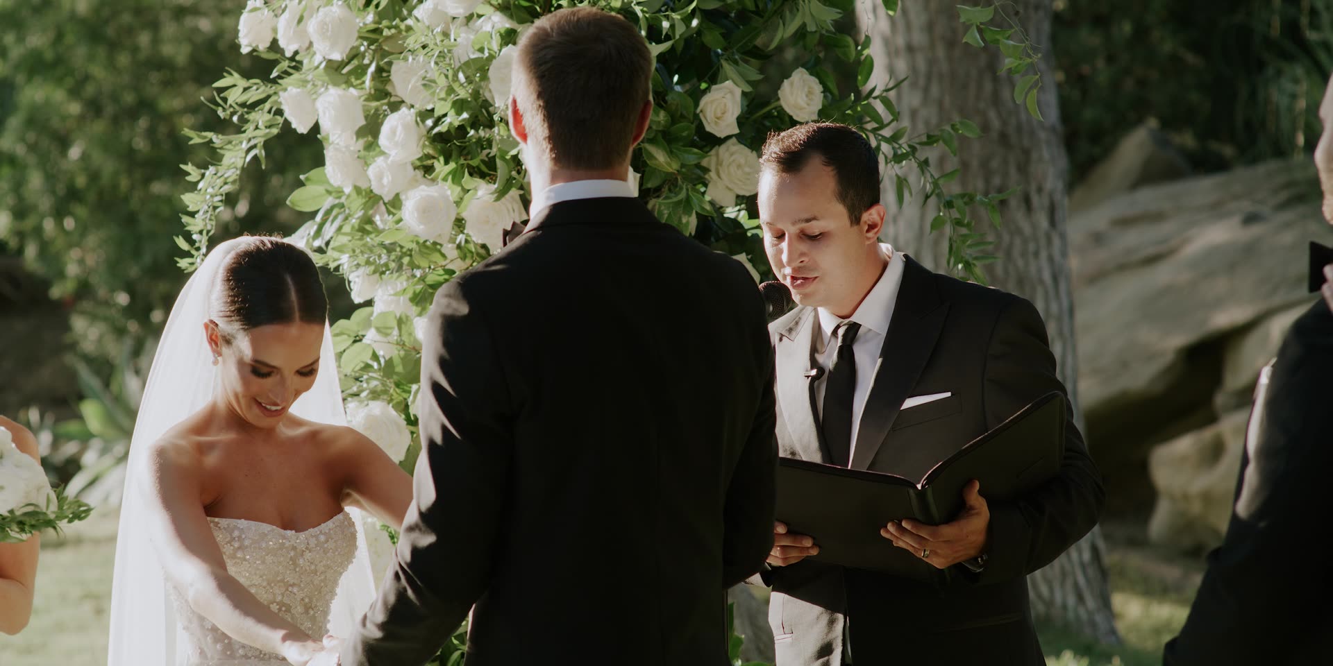 Luke and Anna's ceremony beneath the white floral arch in Santa Susana
