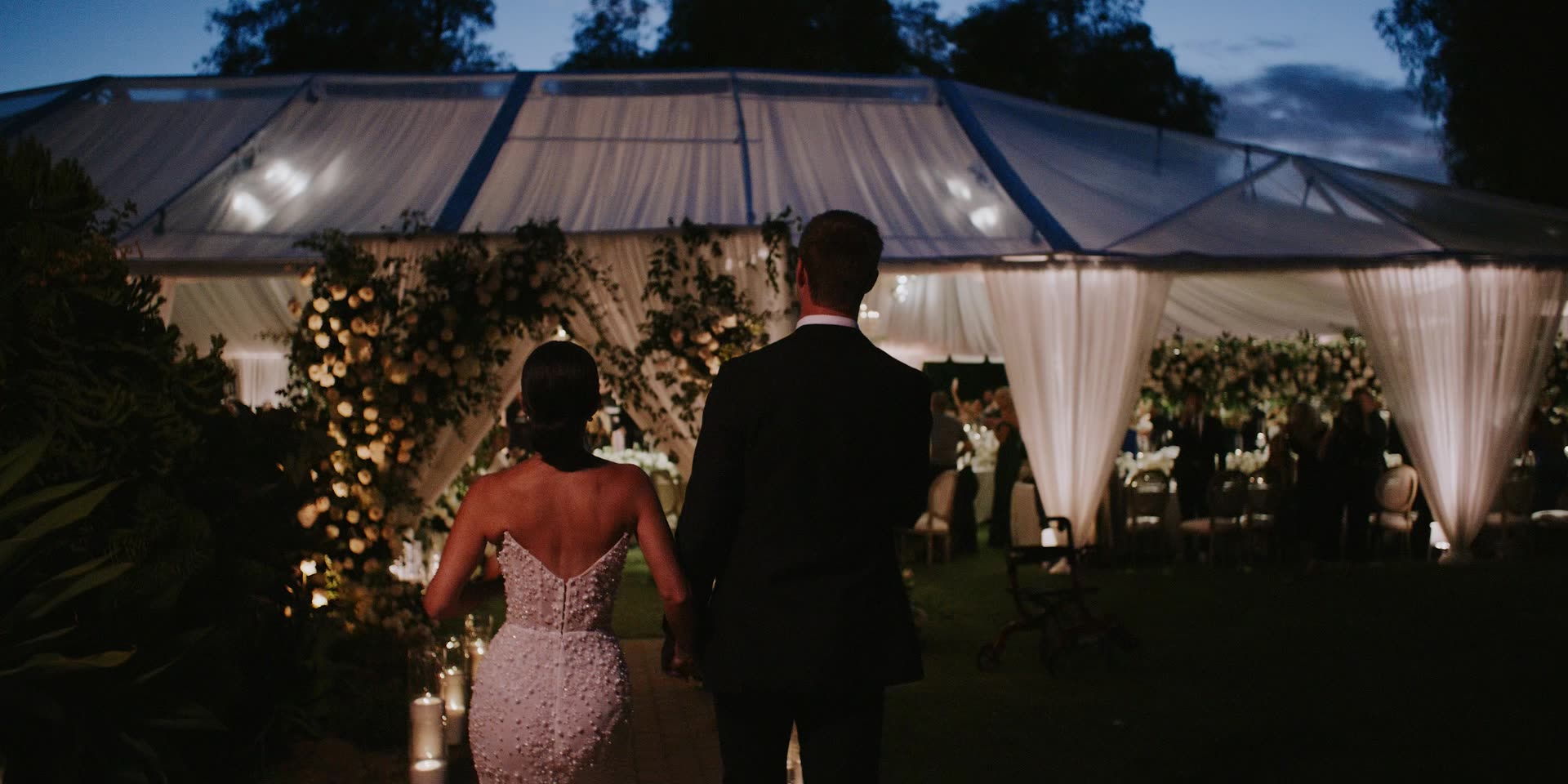 Luke and Anna walking toward the lit tent after dark in Santa Susana